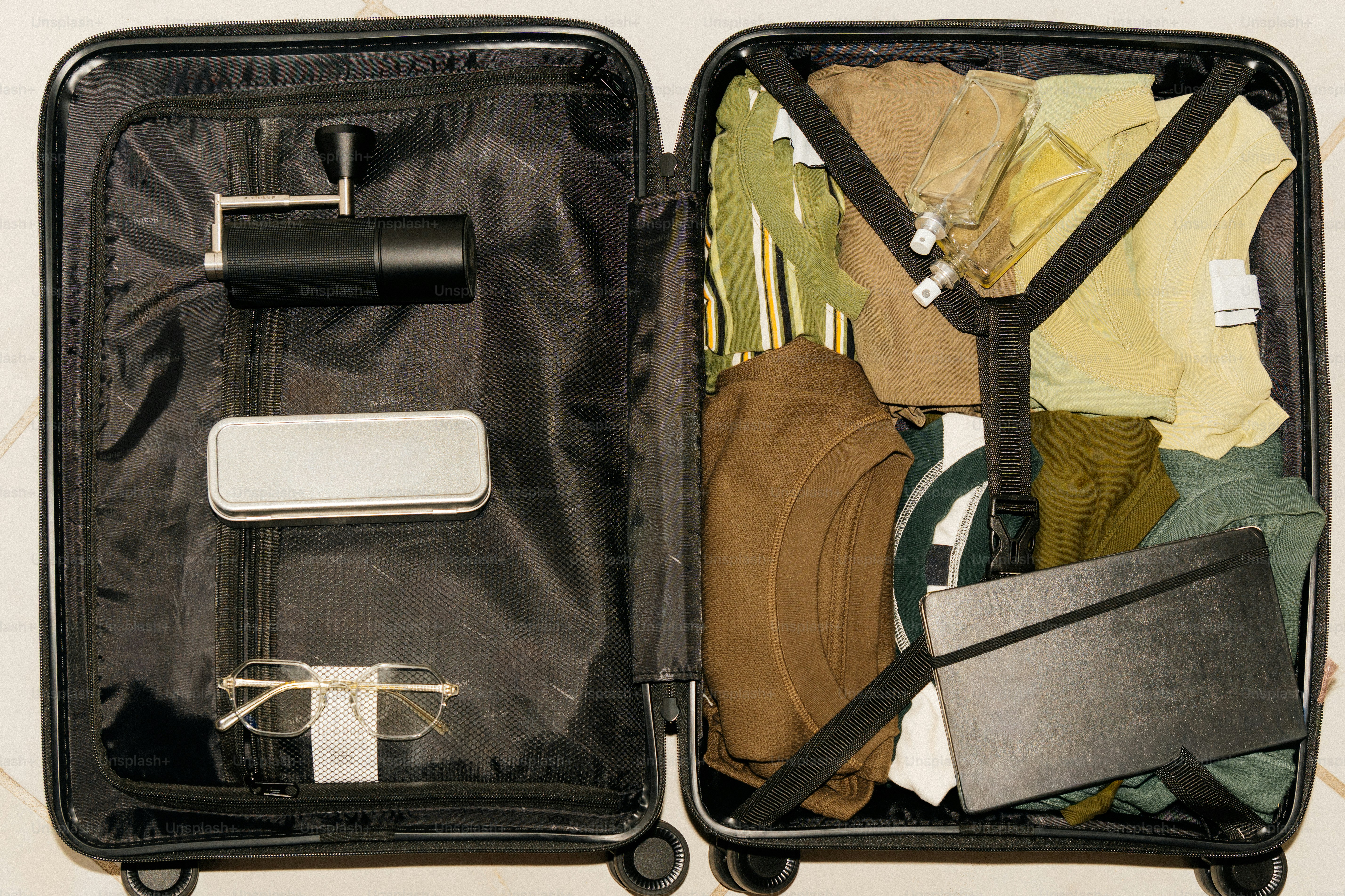 Open suitcase packed with clothes and accessories.
