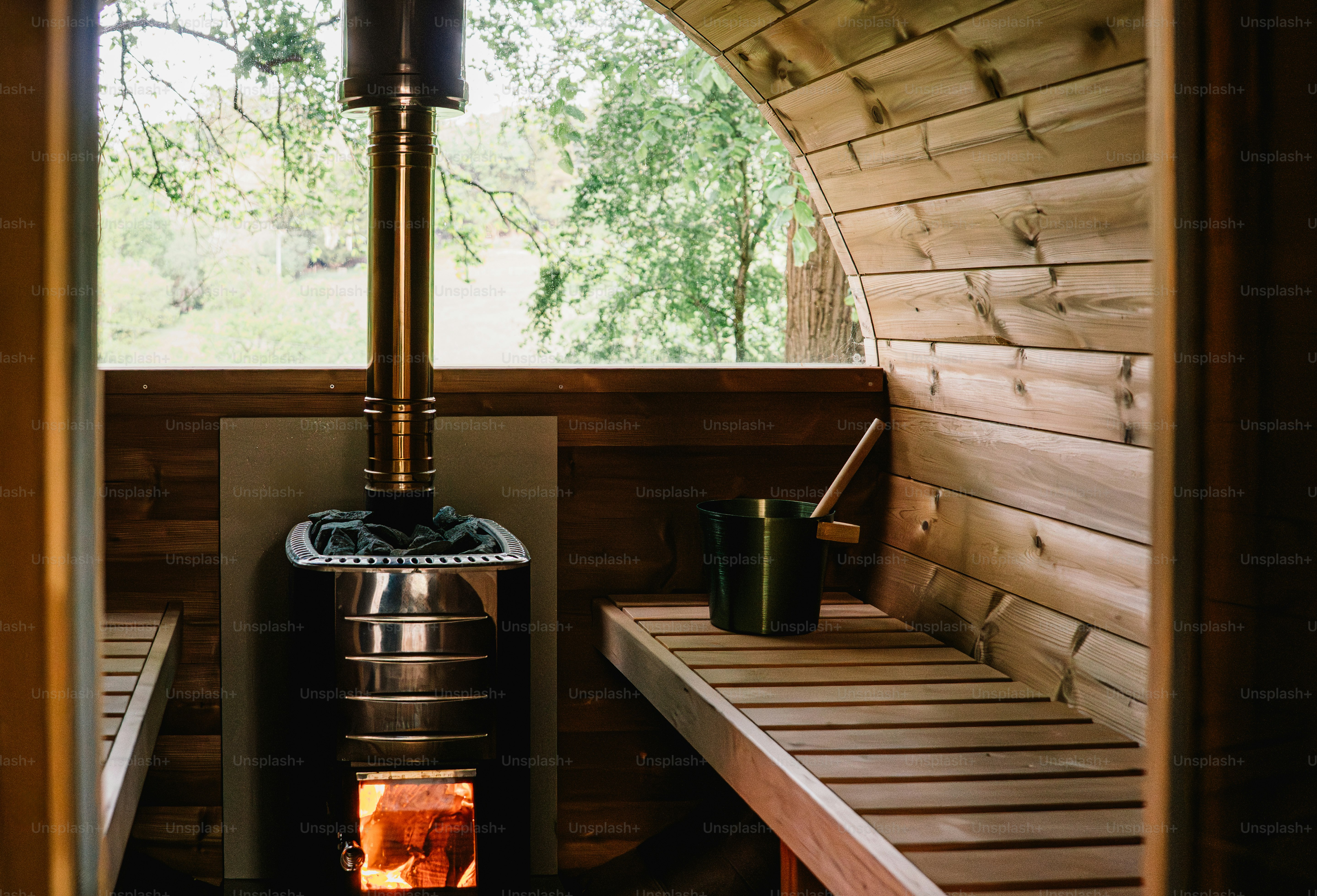 Interior sauna kayu dengan kompor dan bangku