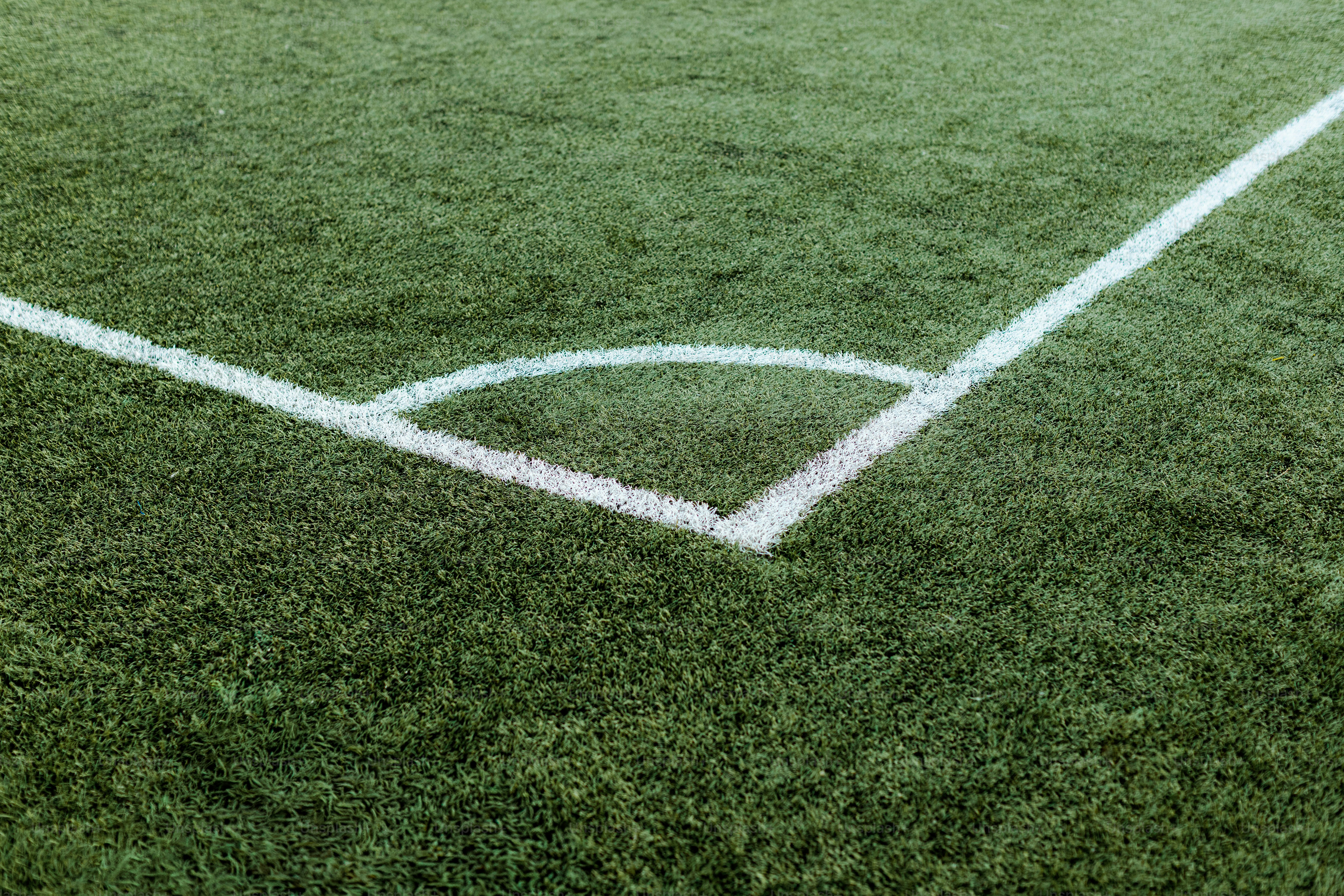 Sudut lapangan sepak bola hijau dengan garis putih