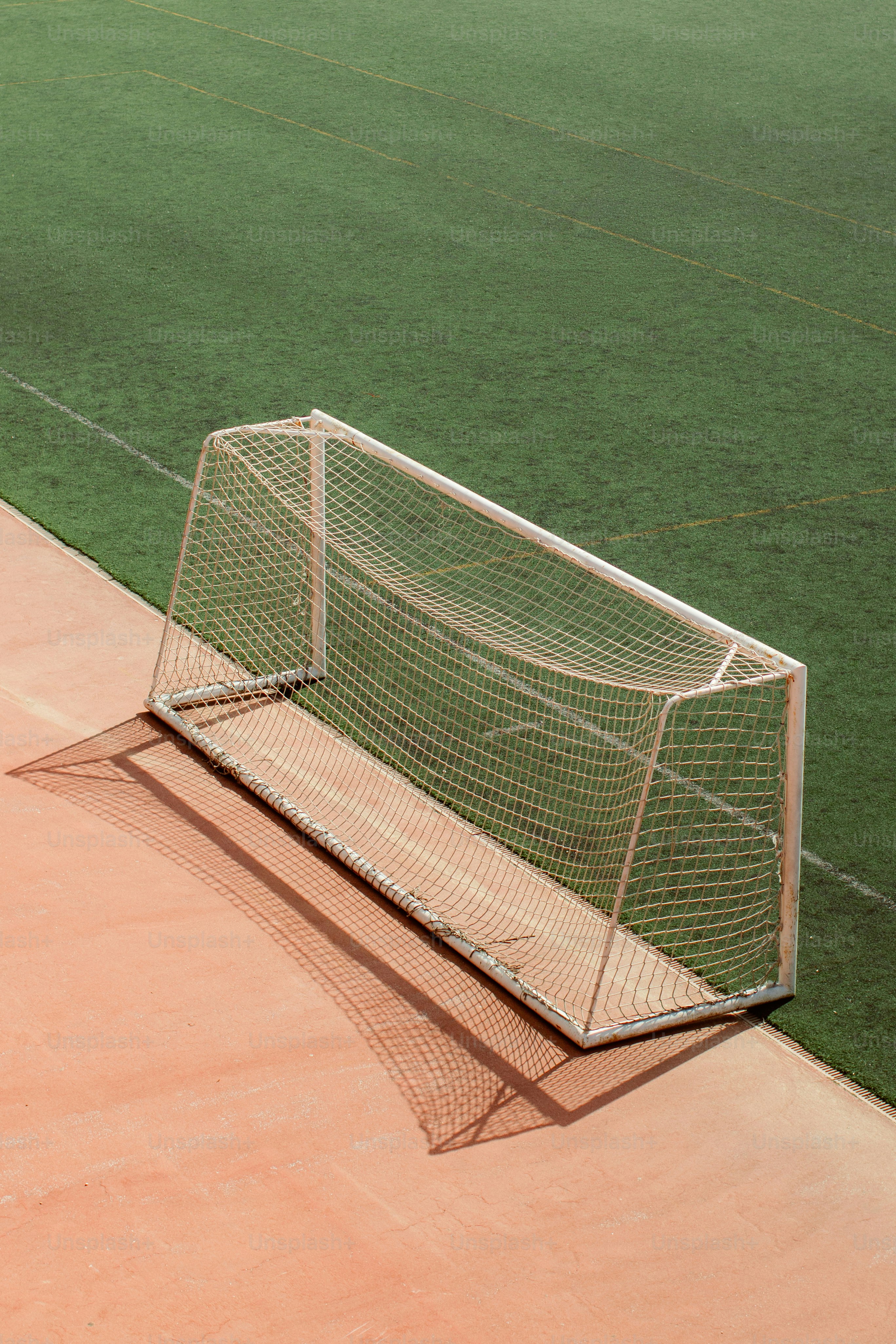 Gawang sepak bola di lapangan dengan rumput hijau.