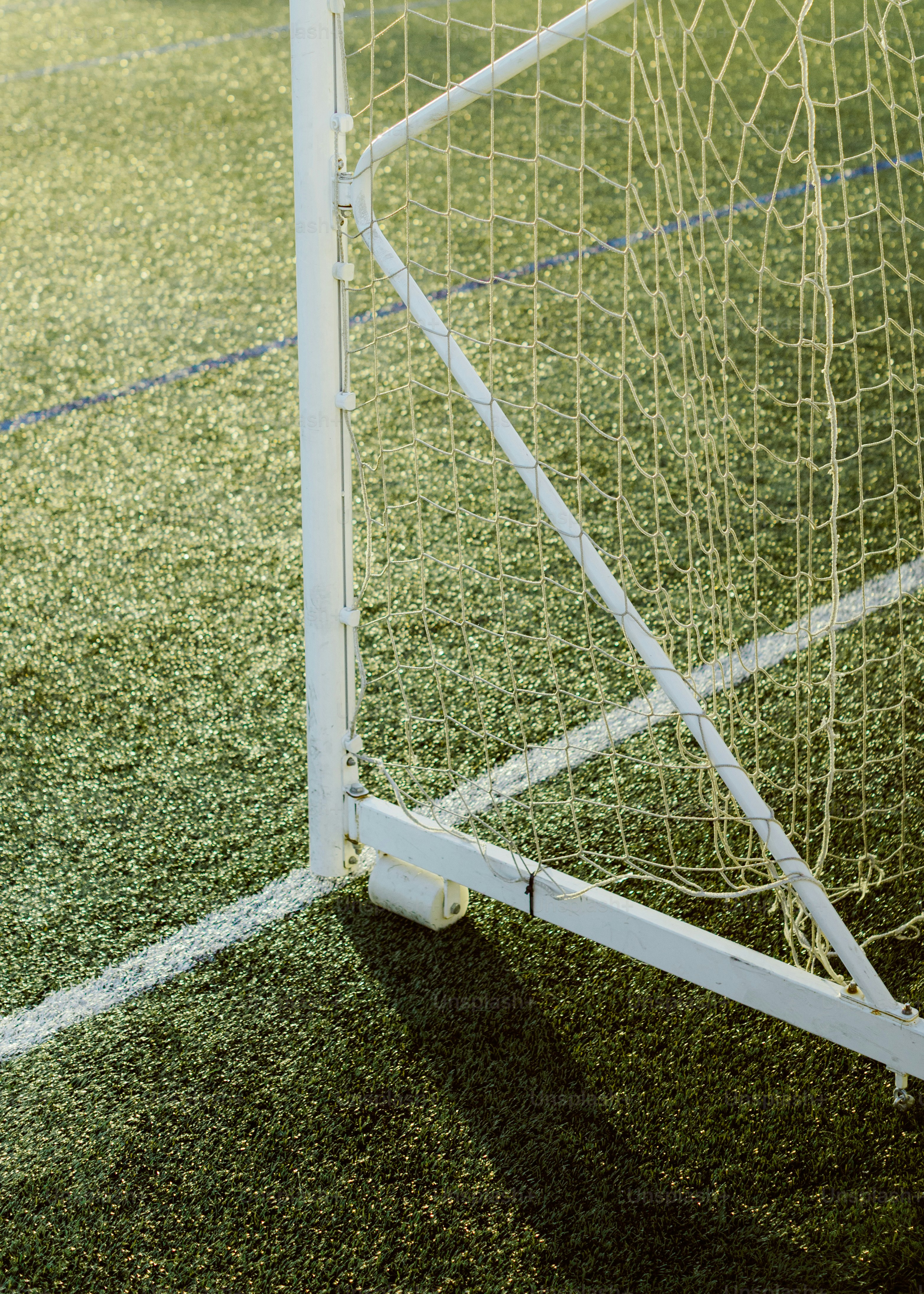Tiang gawang sepak bola putih di lapangan hijau
