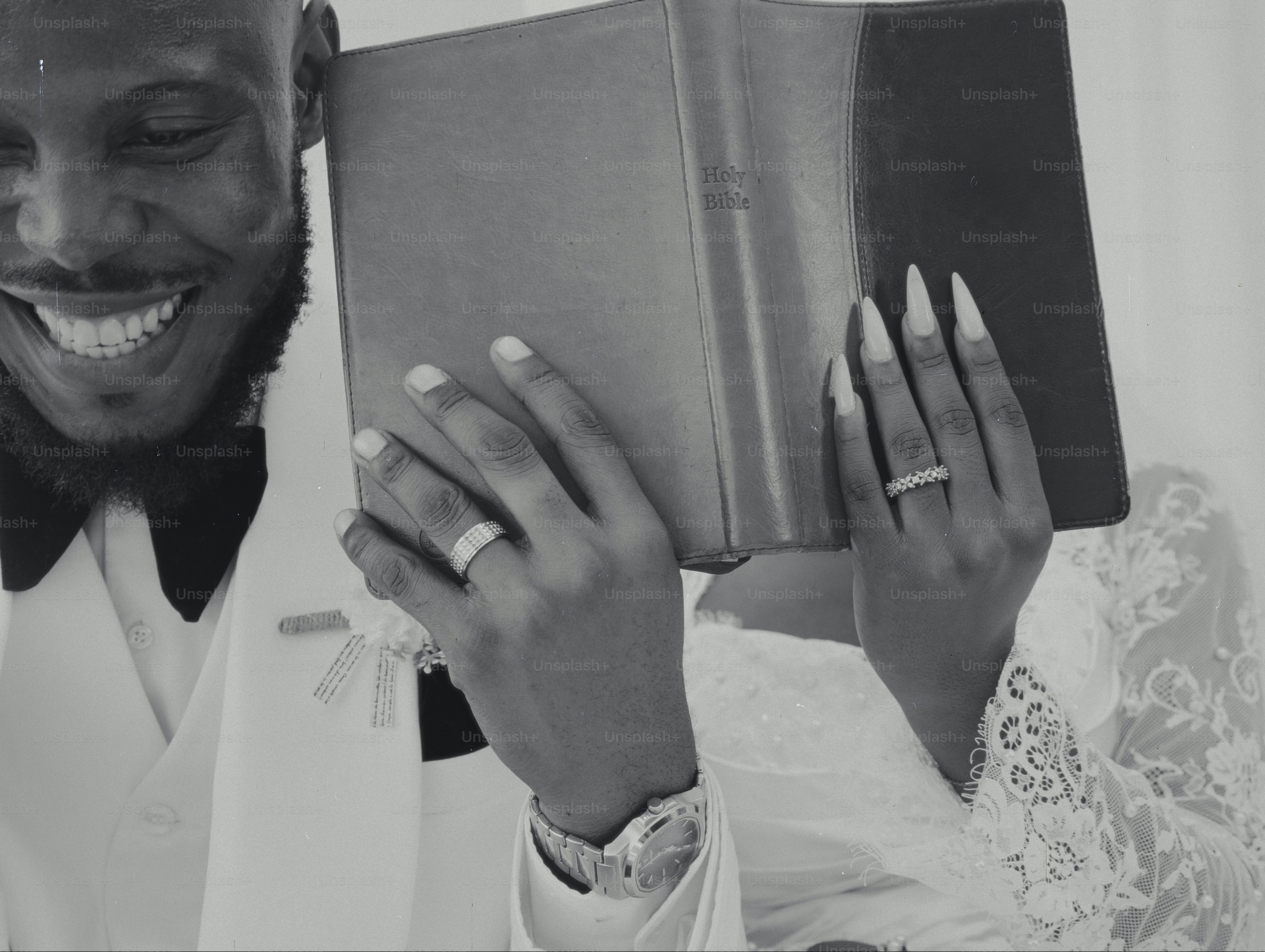 Couple holding a book, showing wedding rings.