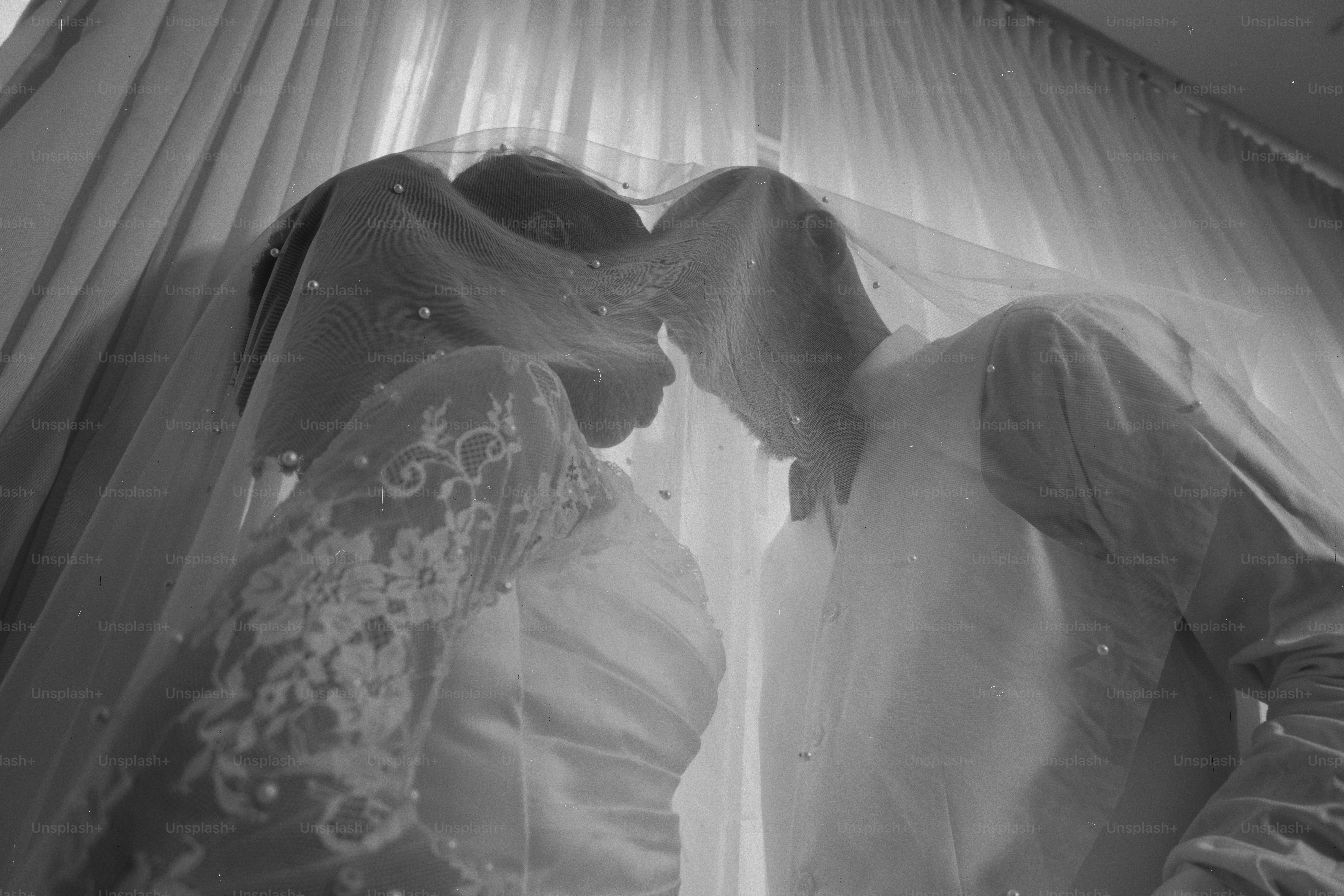 A bride and groom share a tender moment under veil