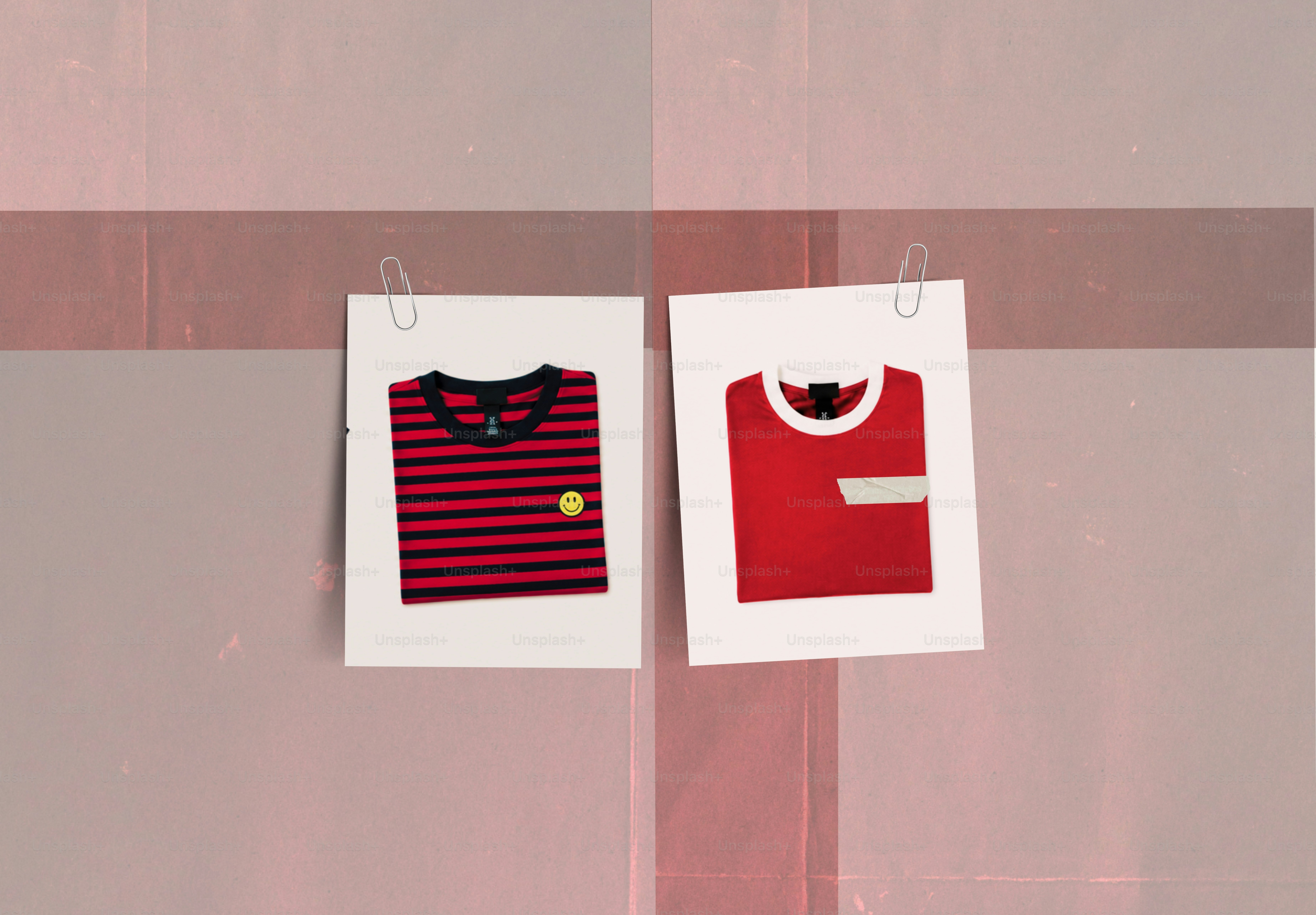 Deux t-shirts rouges épinglés sur un fond rouge clair.