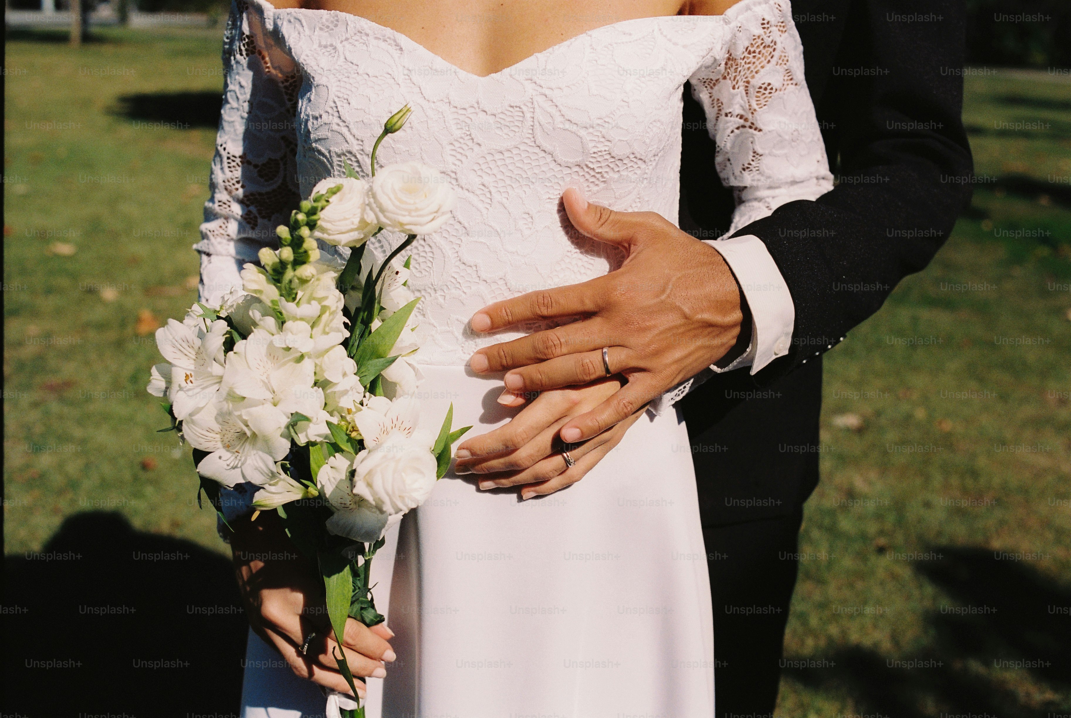 Joyful couple smiling at each other, holding a white bouquet. photo ...