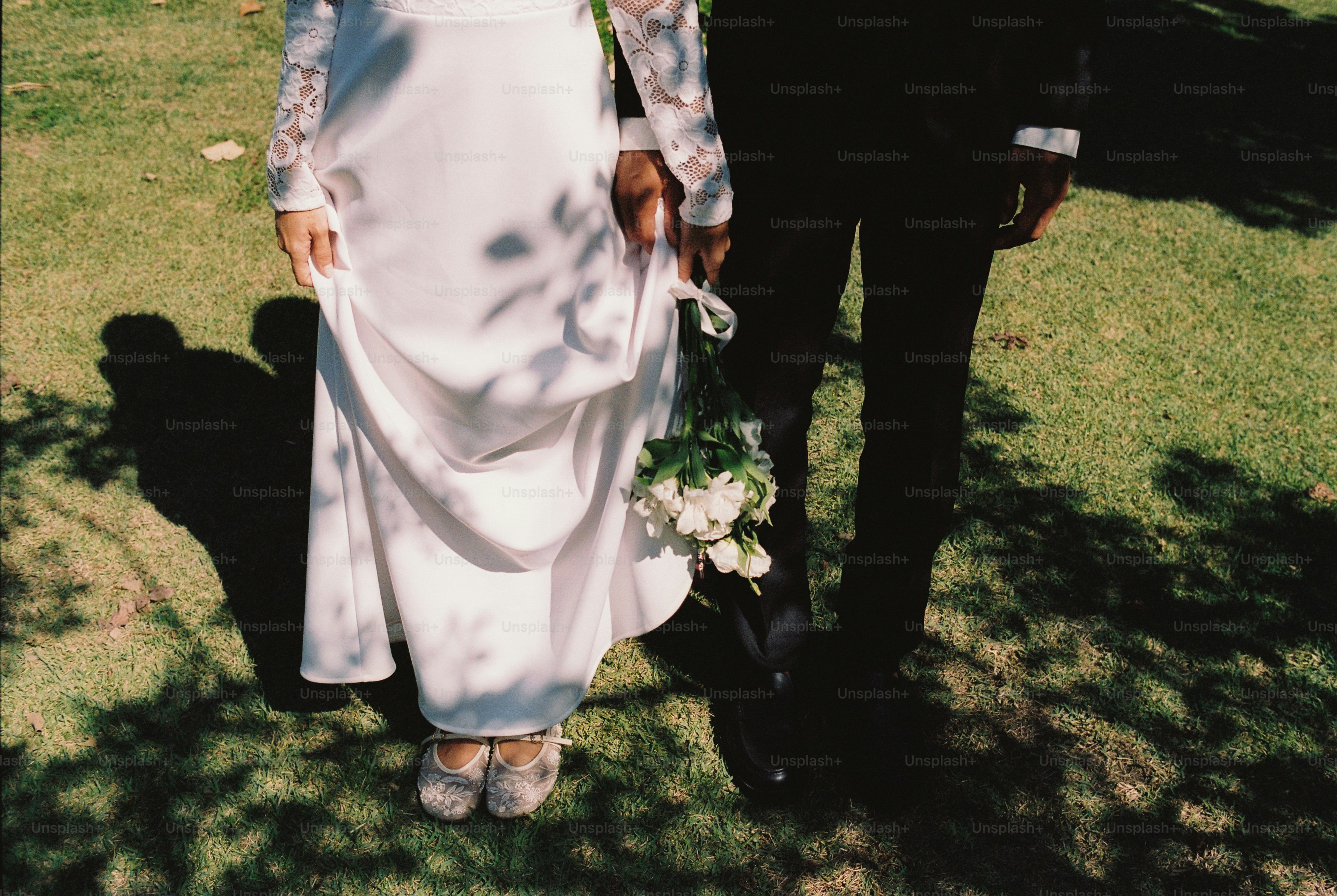 Pengantin di atas rumput, memegang buket bunga putih.