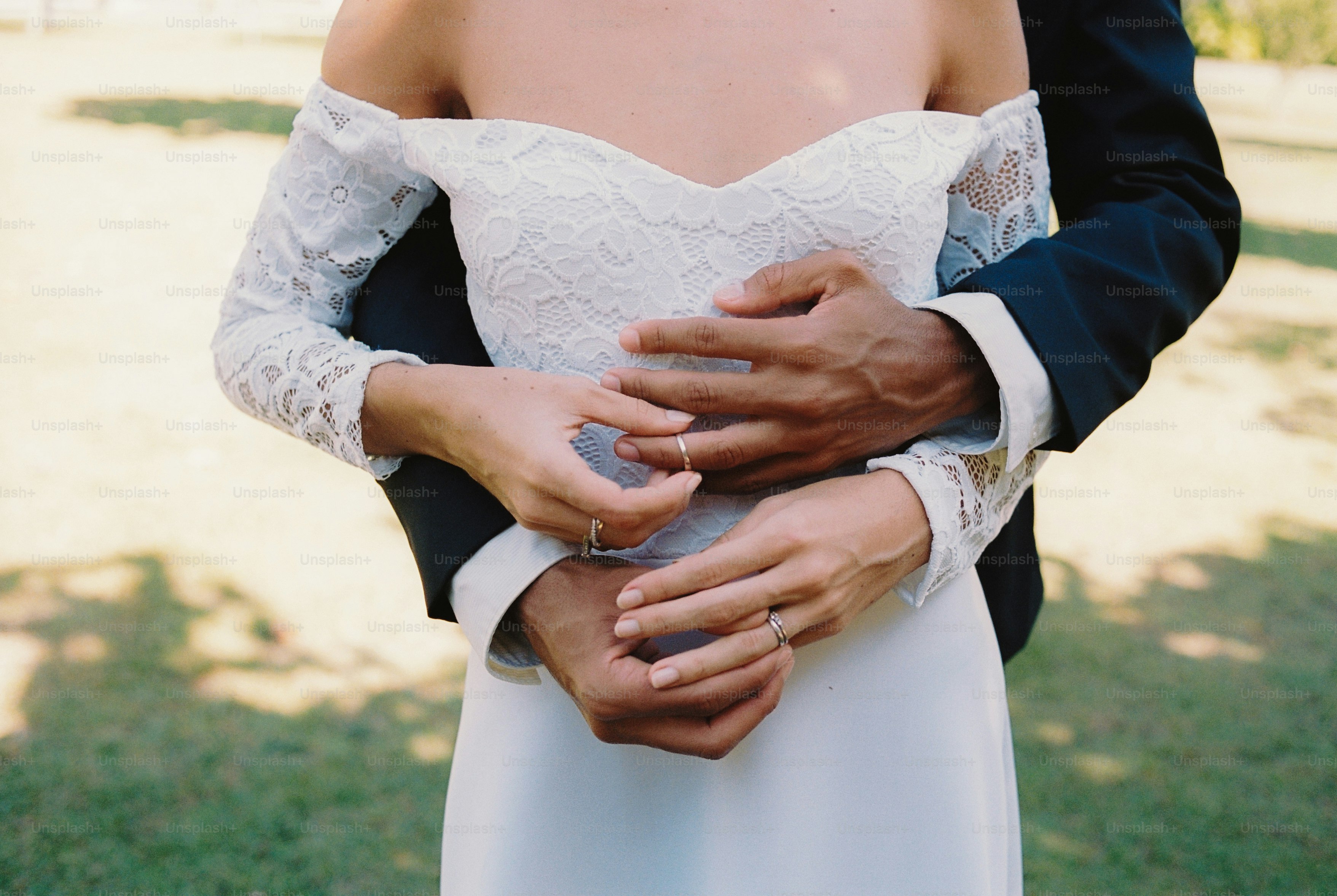 Pengantin pria berpelukan, tangan di pinggang