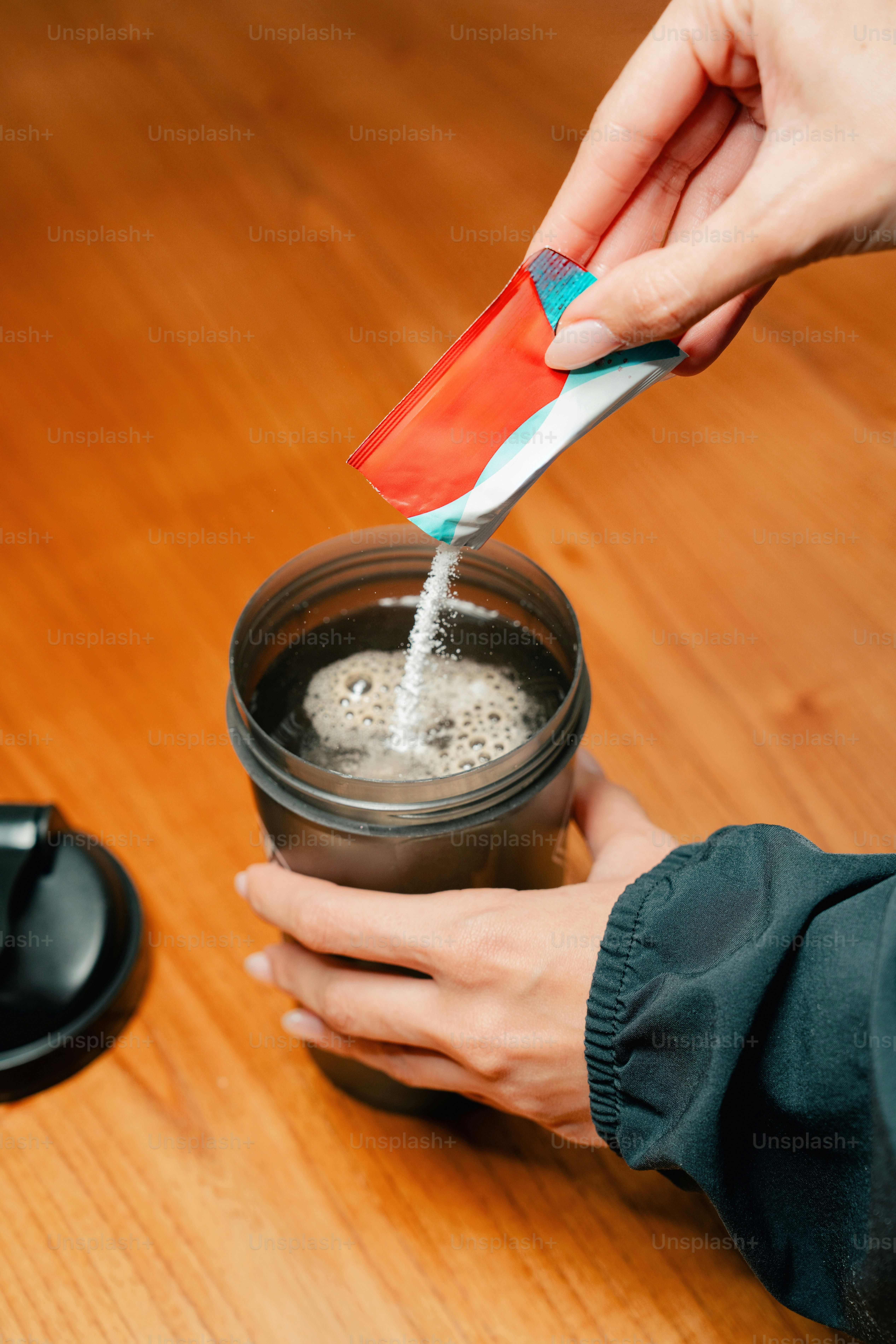Woman pouring powder supplement into shaker bottle. photo – Fitness ...