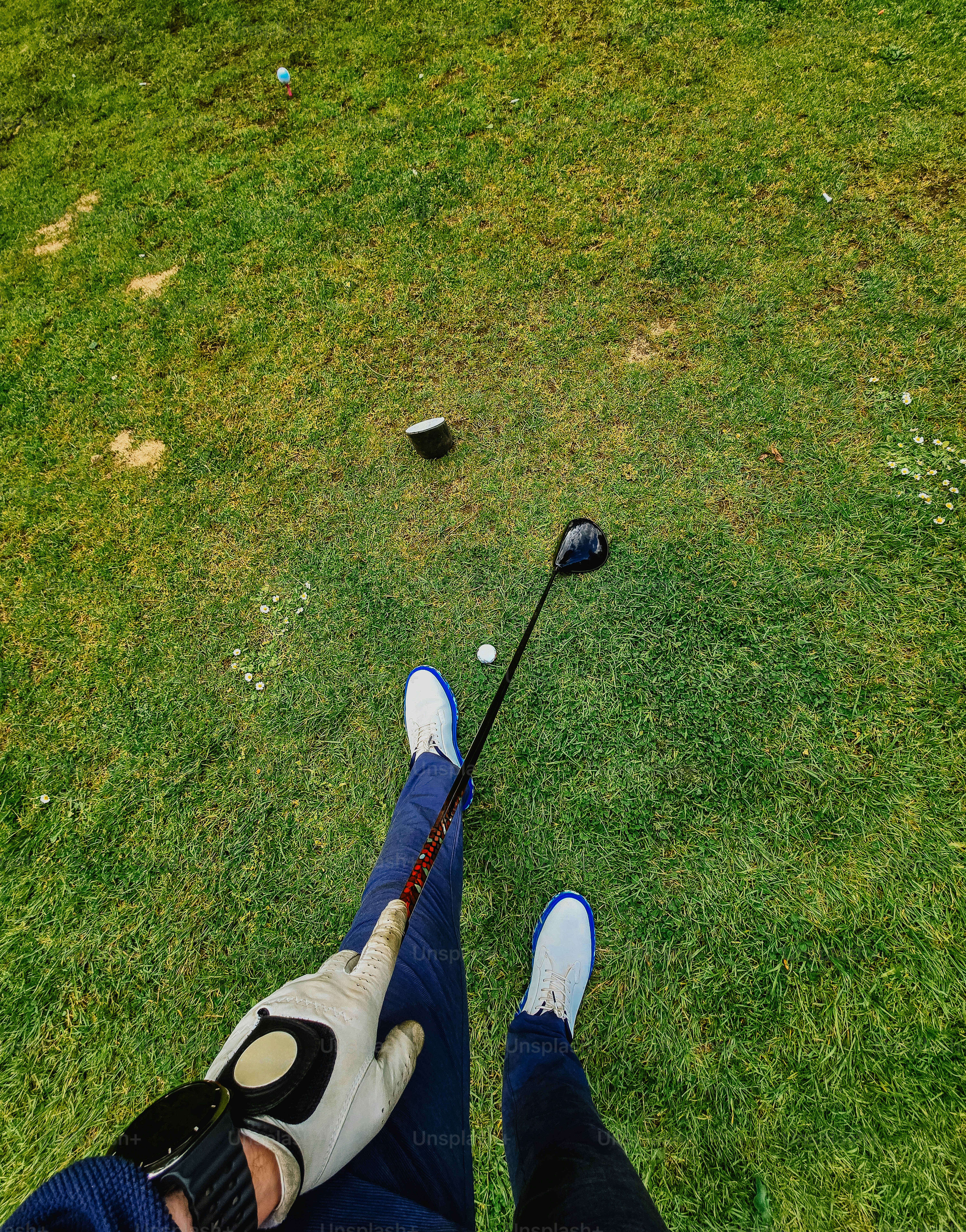 A golfer stands over the ball with a club.