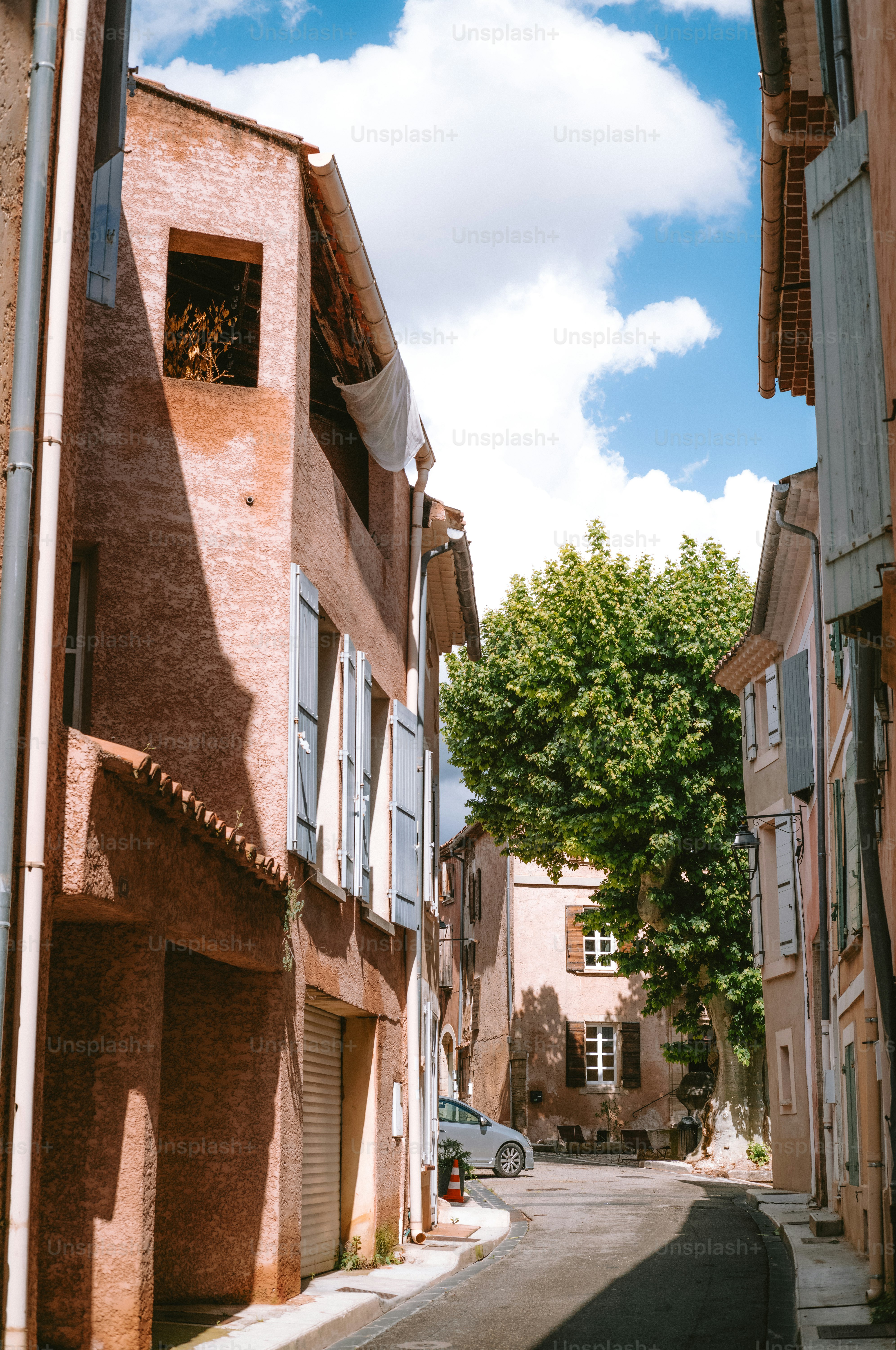 Quaint european street with terracotta buildings and blue shutters.