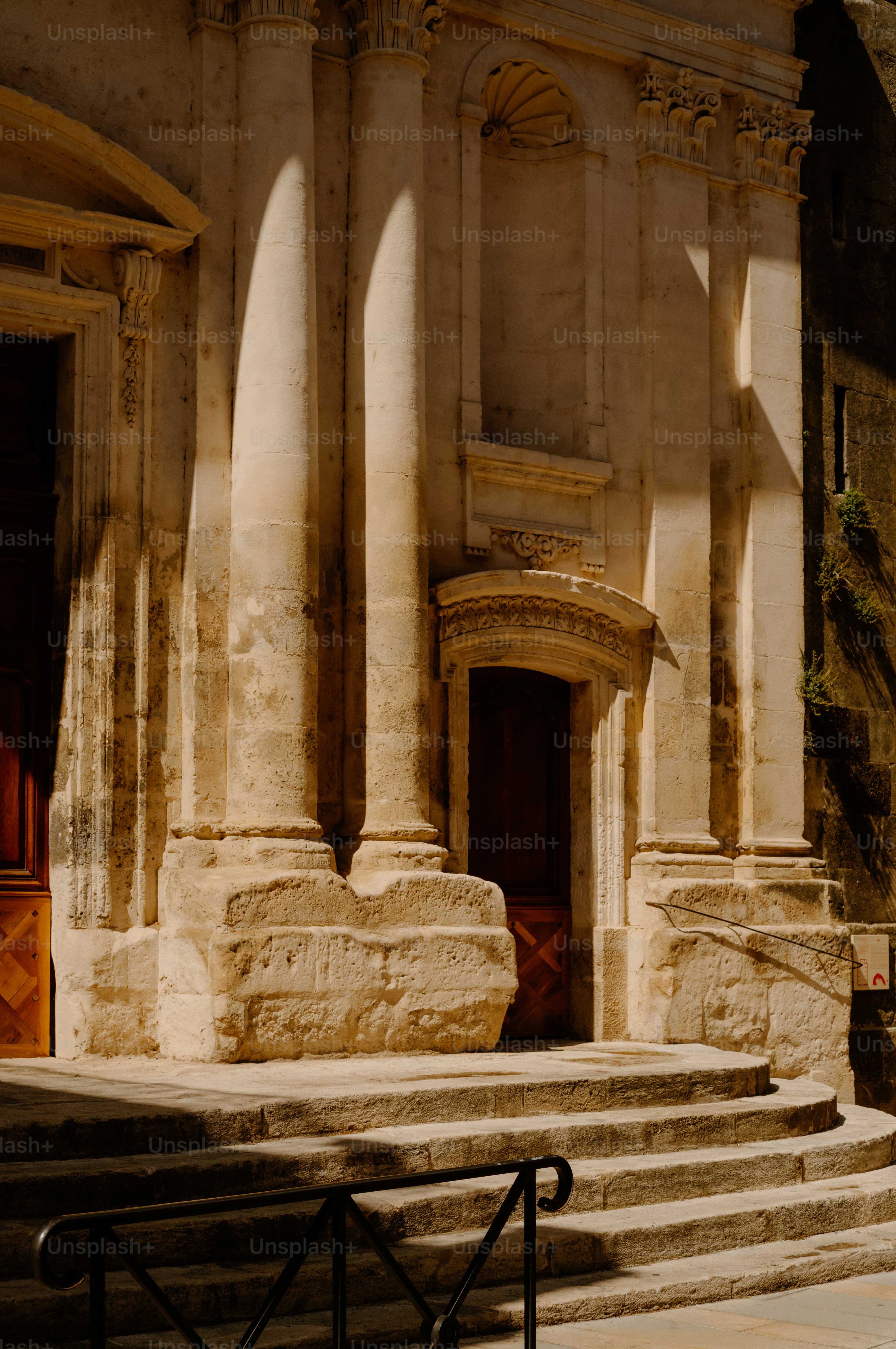 Stone staircase leading to ornate doorway with columns