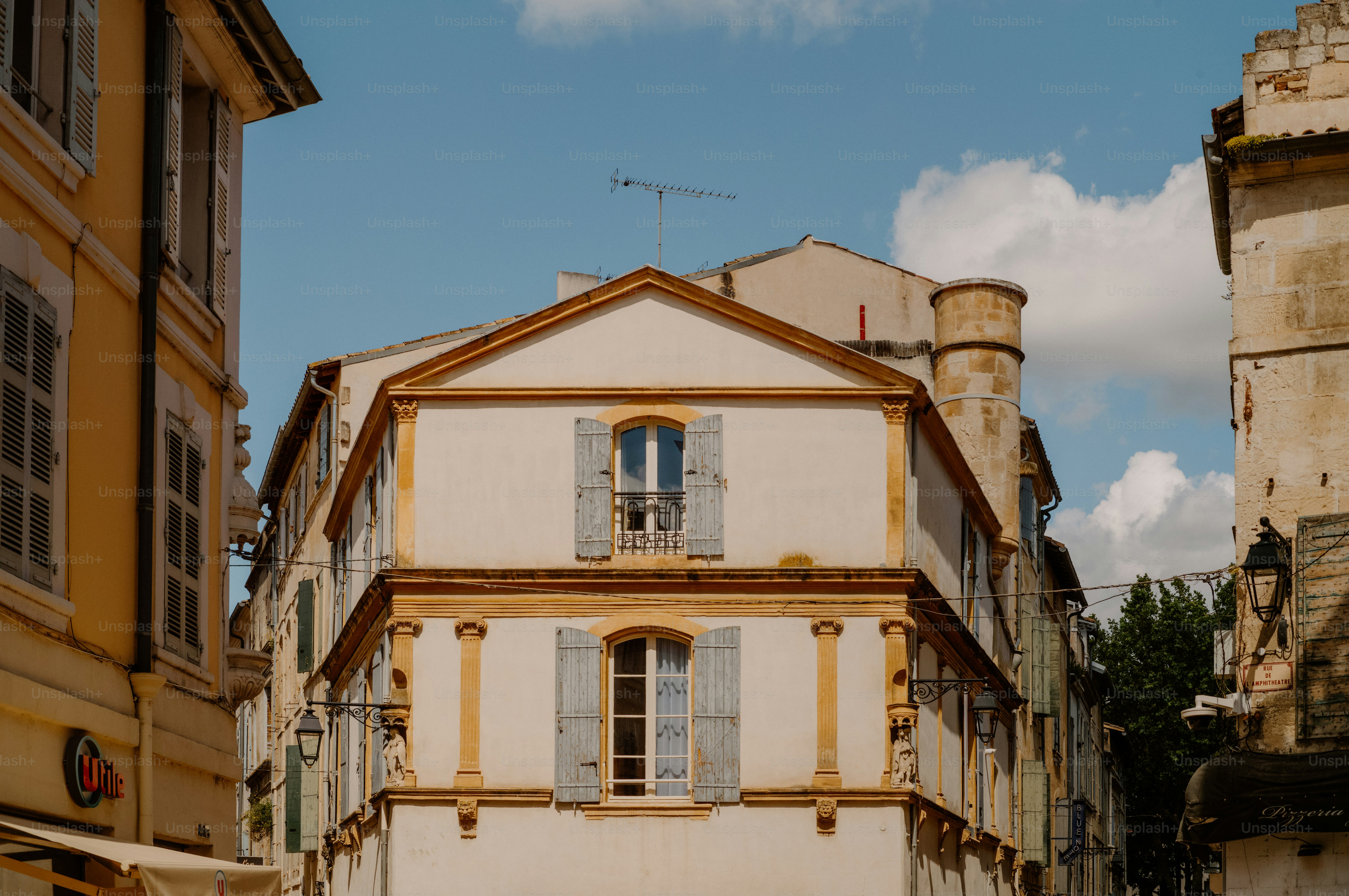 Pale building with blue shutters on a sunny day