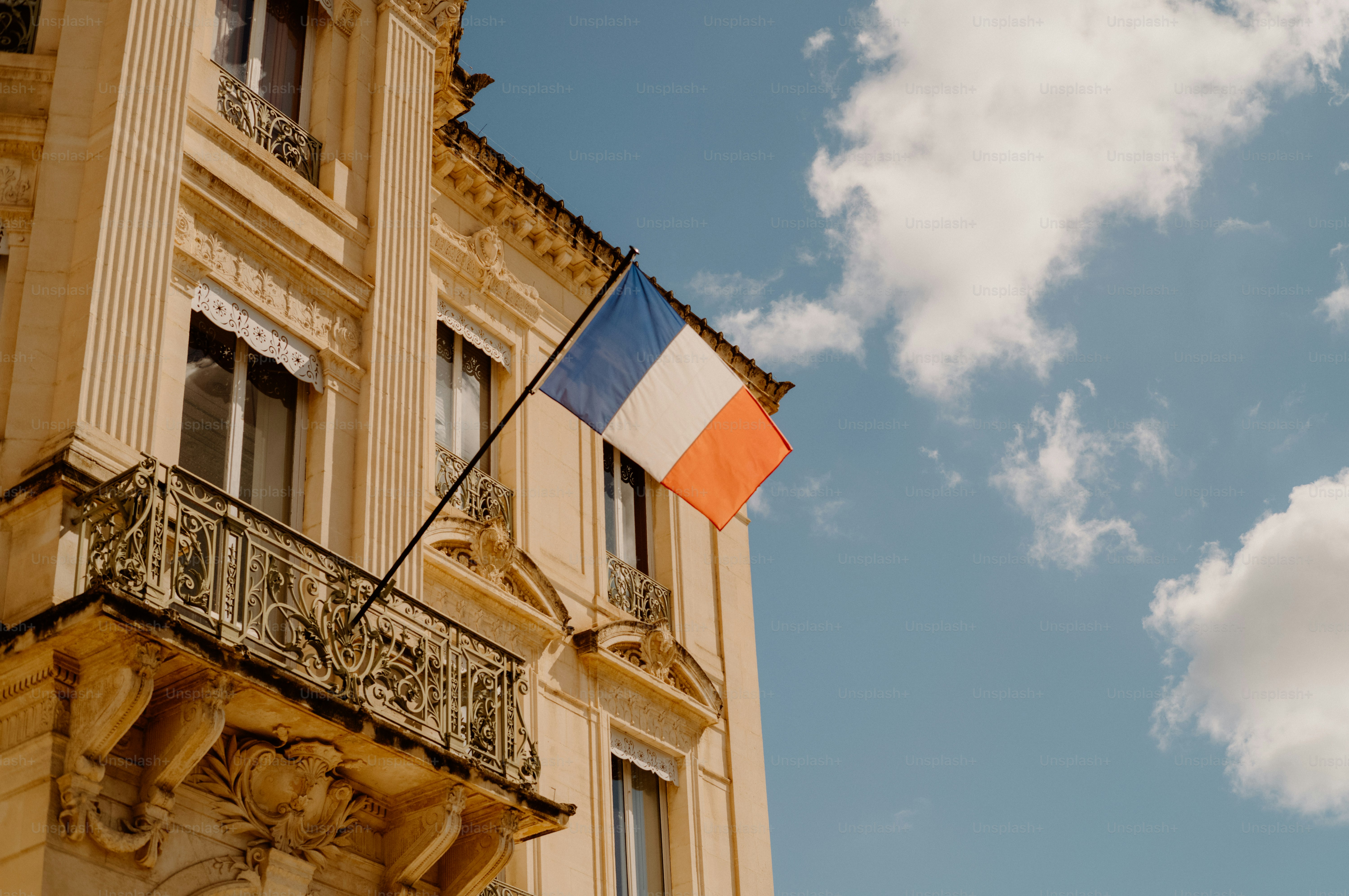 French flag on an ornate building under a blue sky