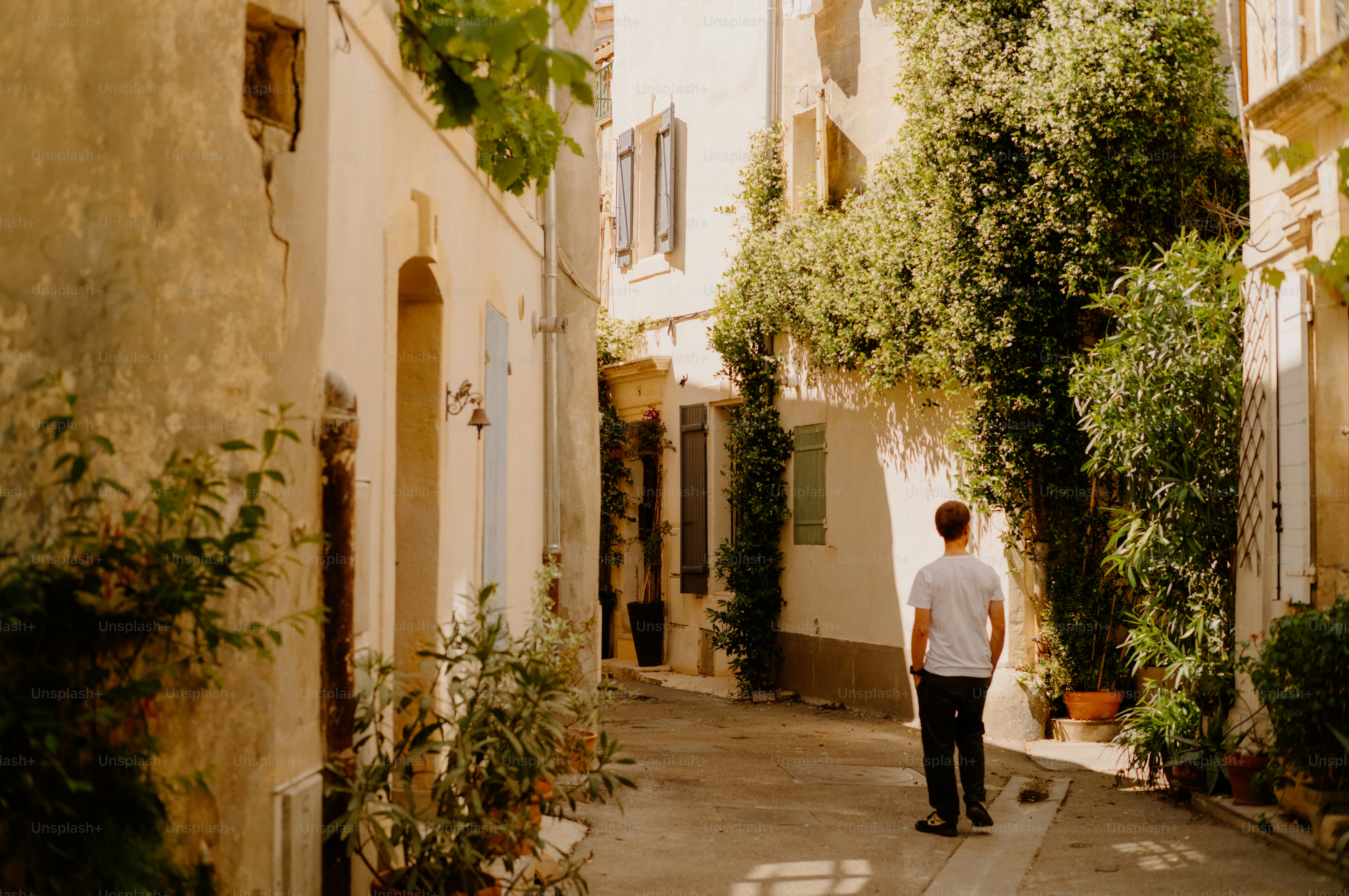 Man walks down a sunlit european street.