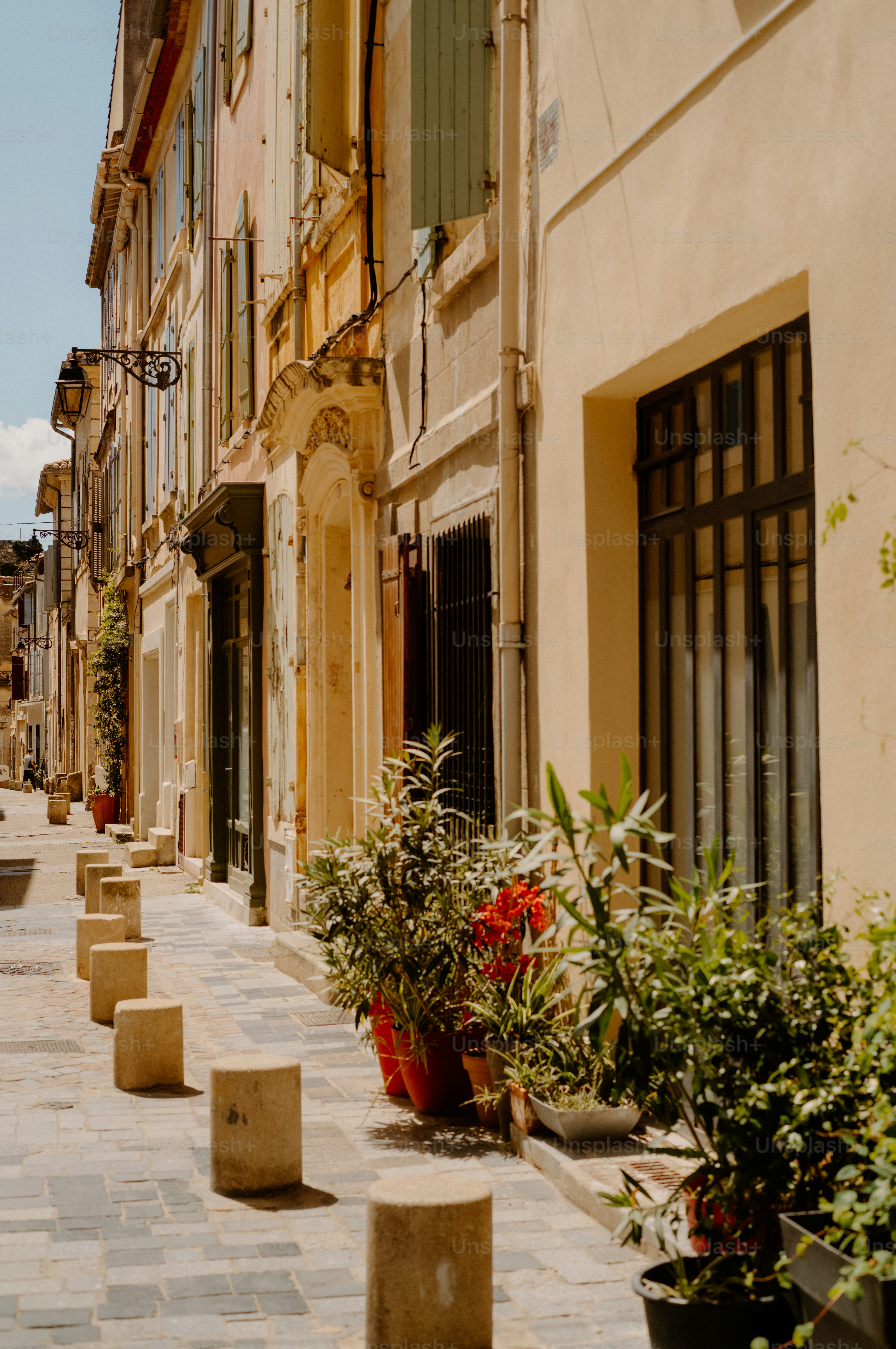 A charming european street with old buildings and potted plants.
