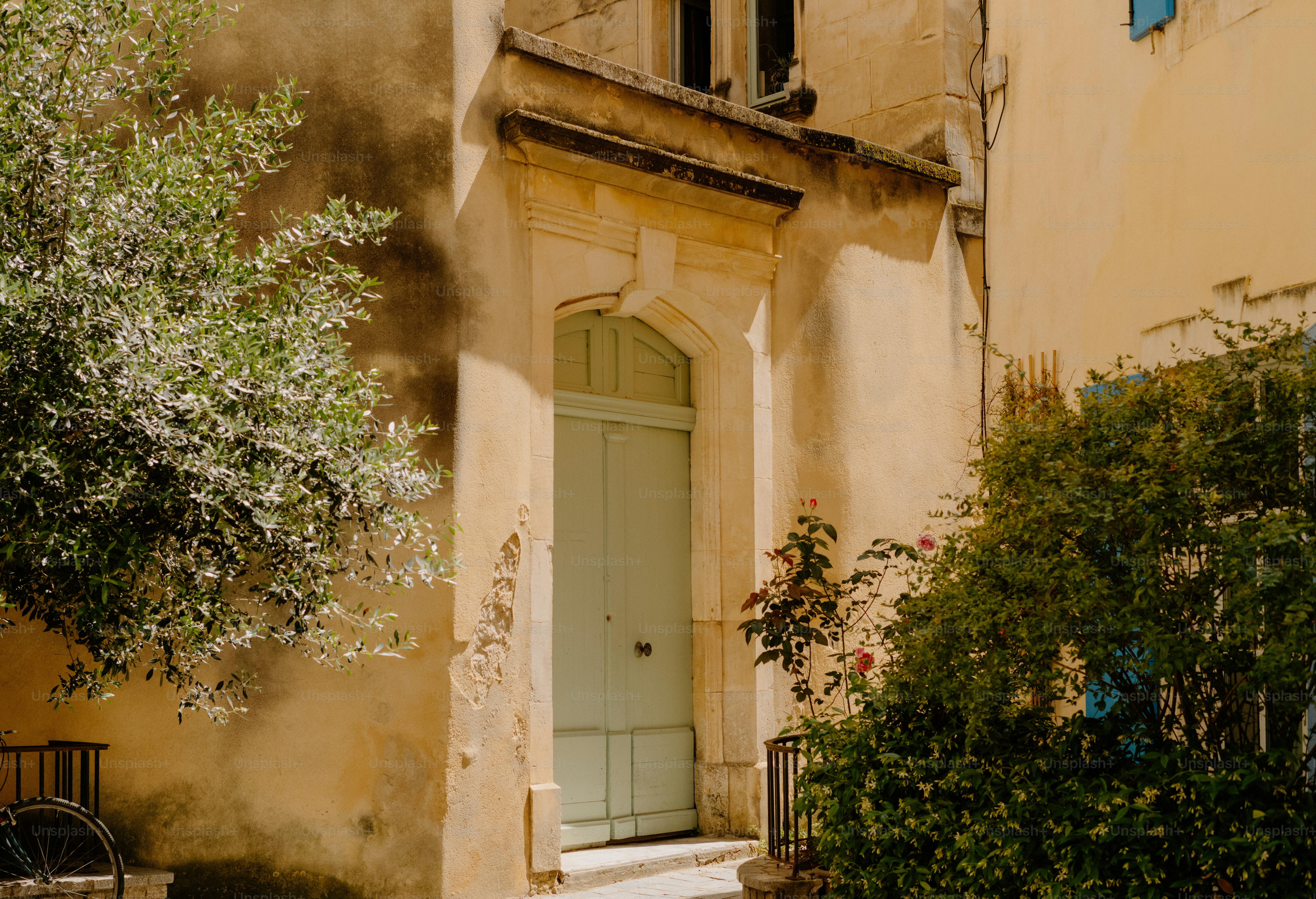 A pale green door on a weathered building