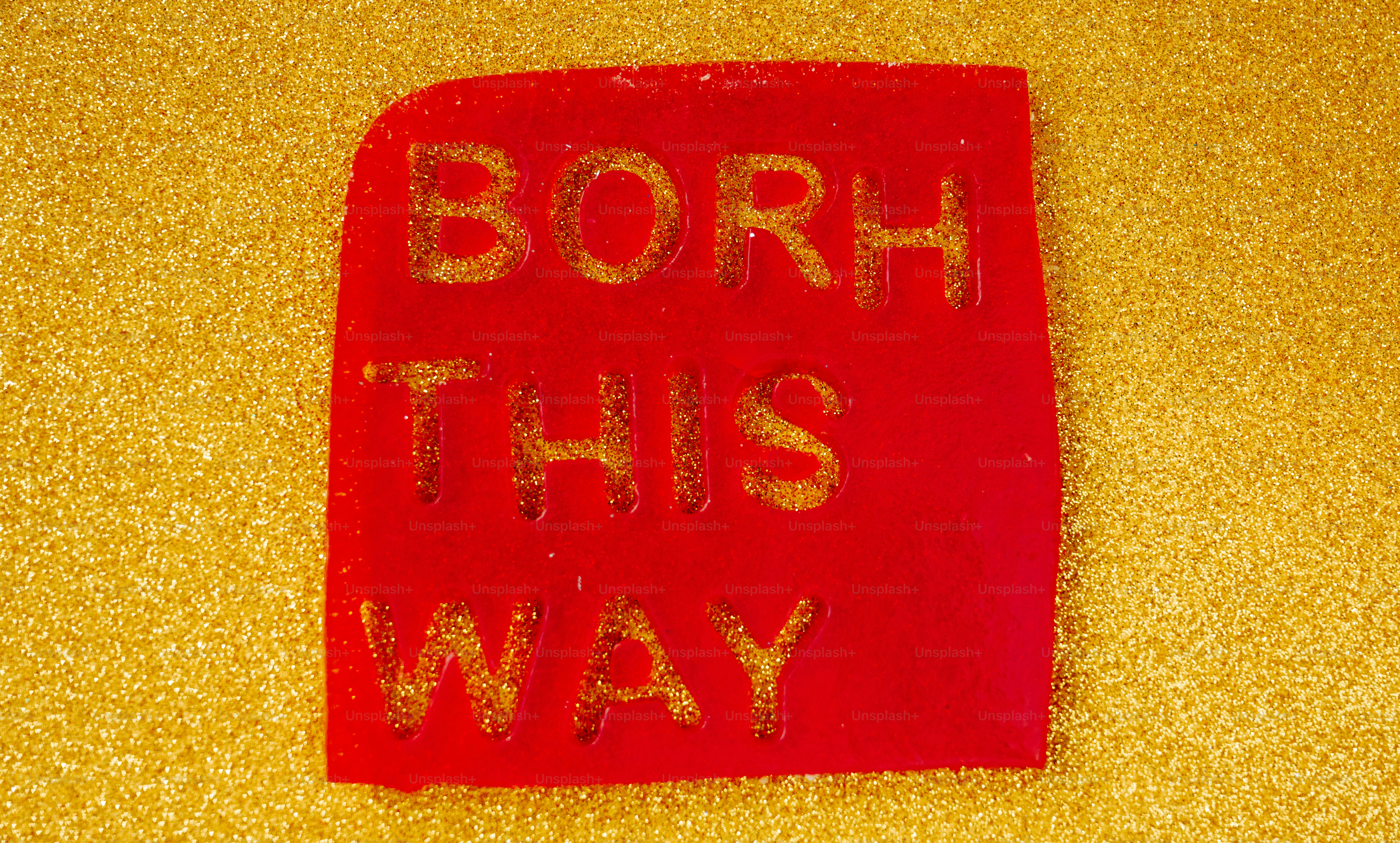 Carré rouge avec un texte doré pailleté « borh par ici »