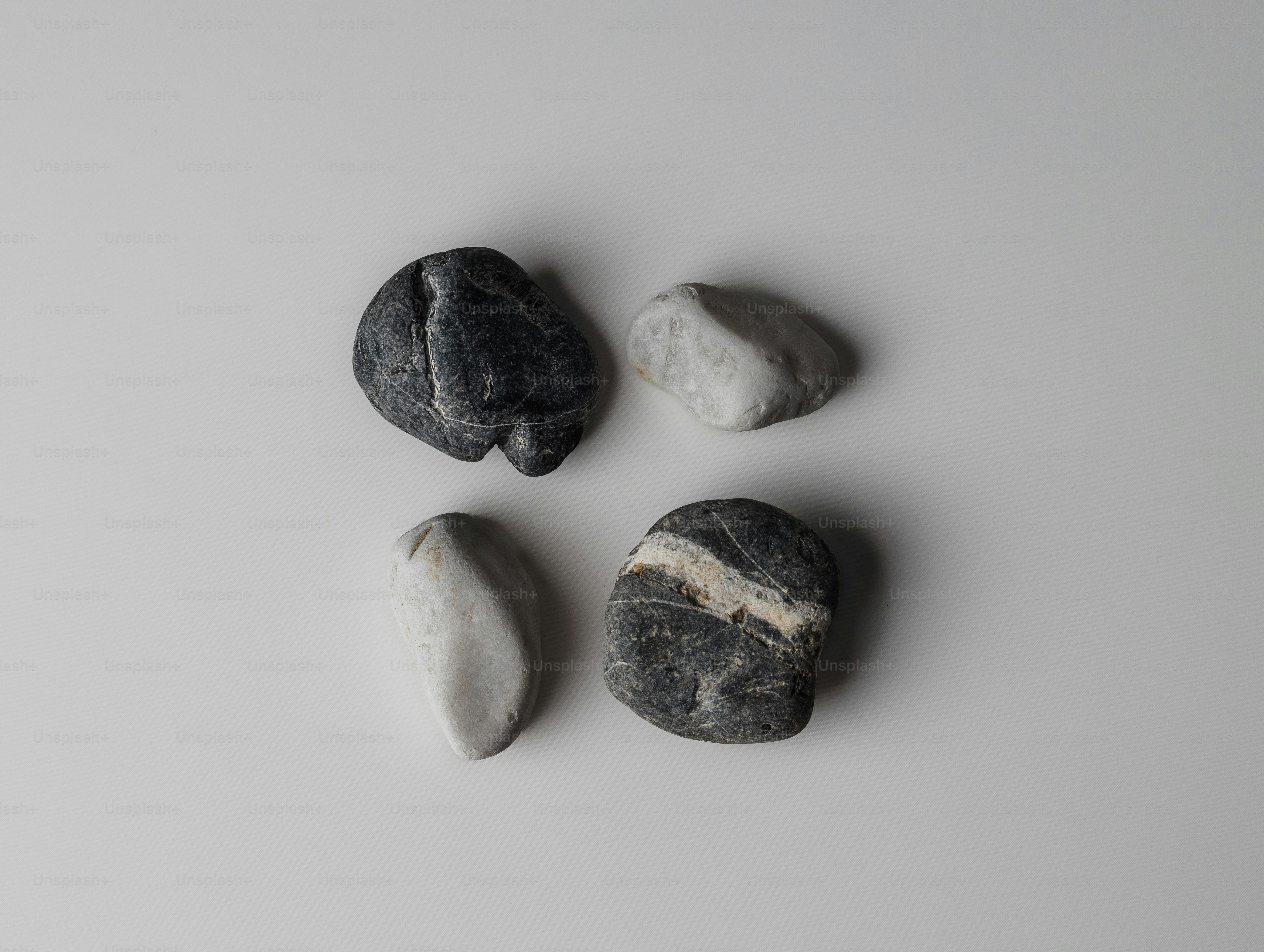 Empat batu hitam putih halus dengan latar belakang putih.