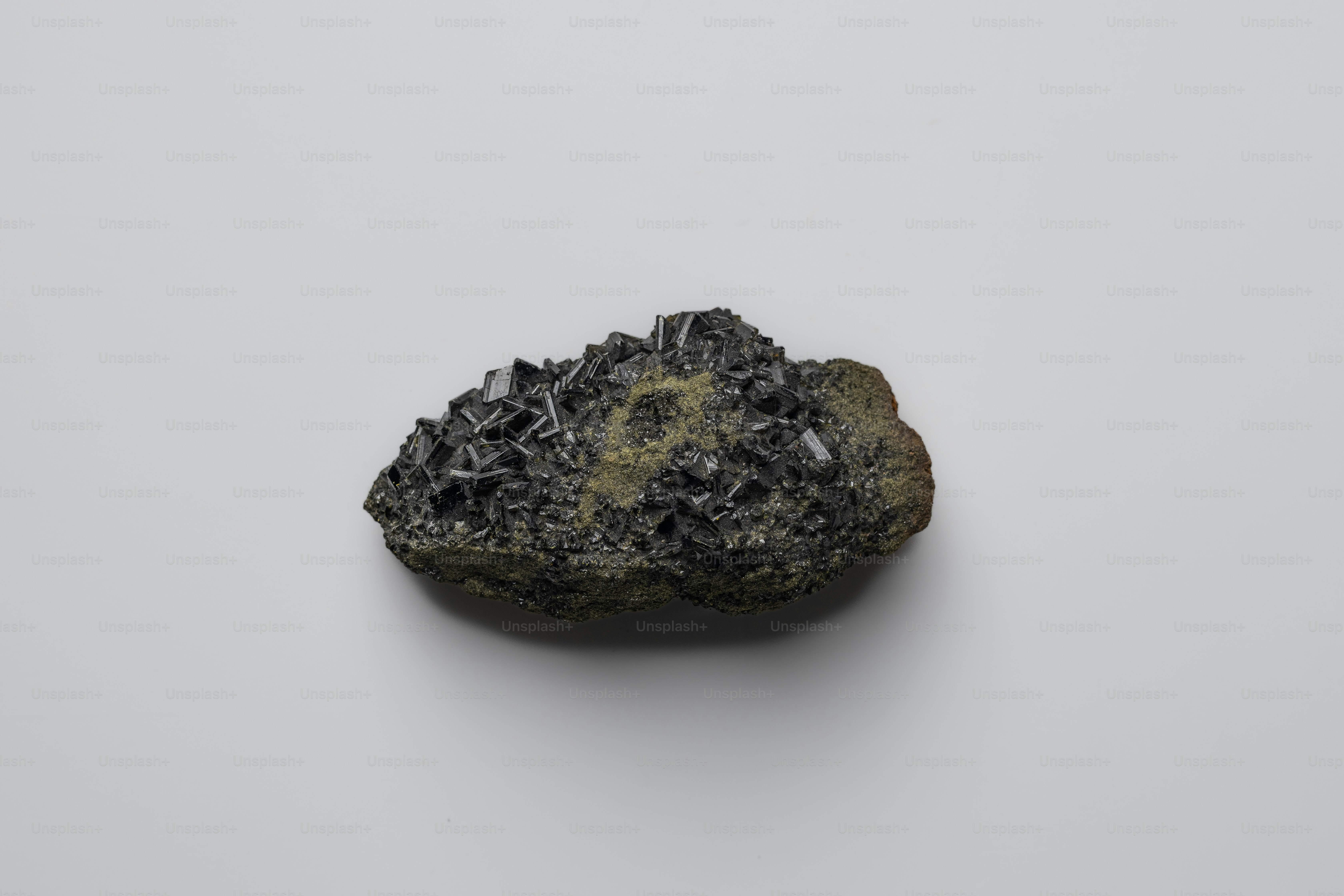 A cluster of dark metallic crystals on a rock. photo – Rock Image on ...