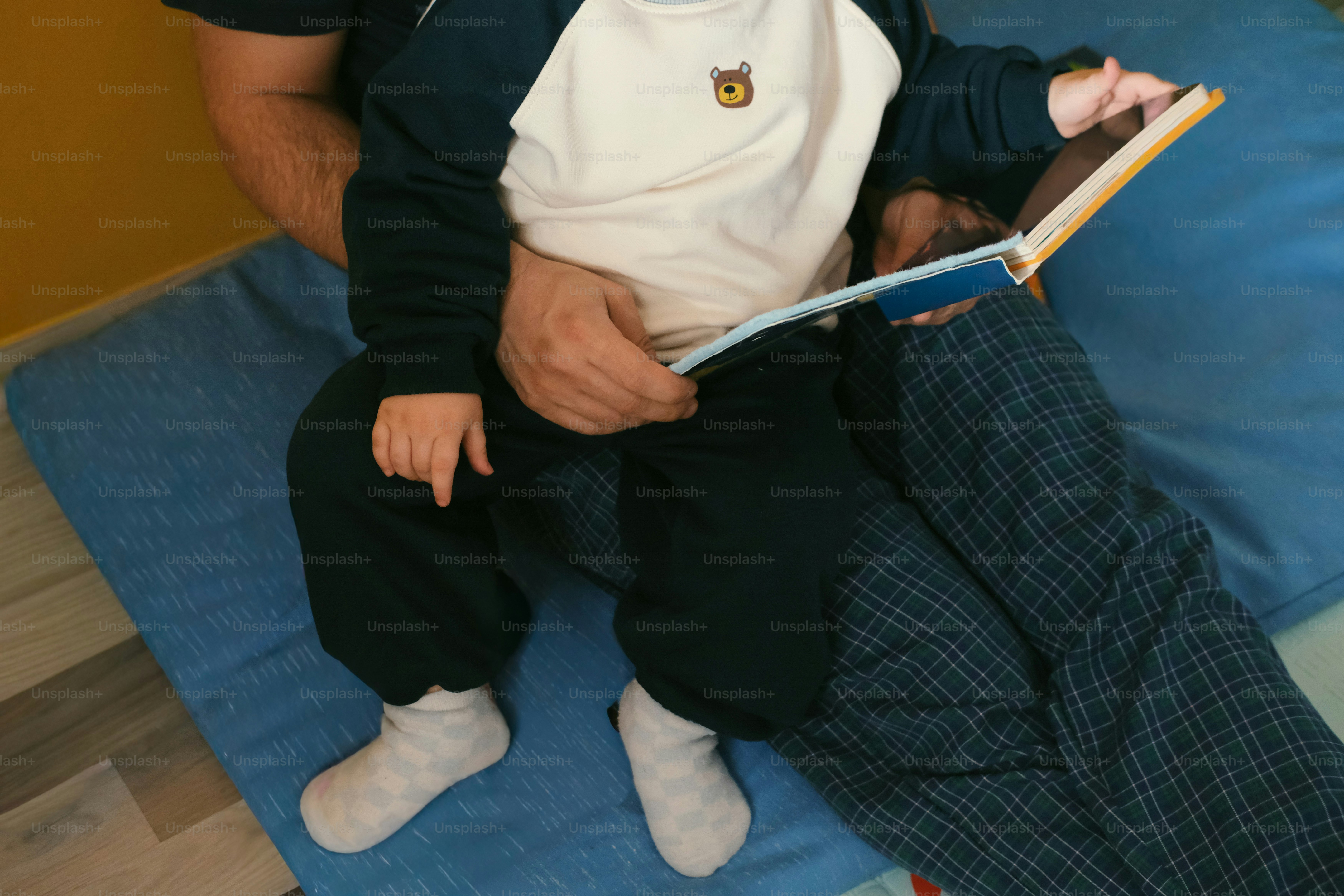 Adulto che legge un libro con un bambino in grembo