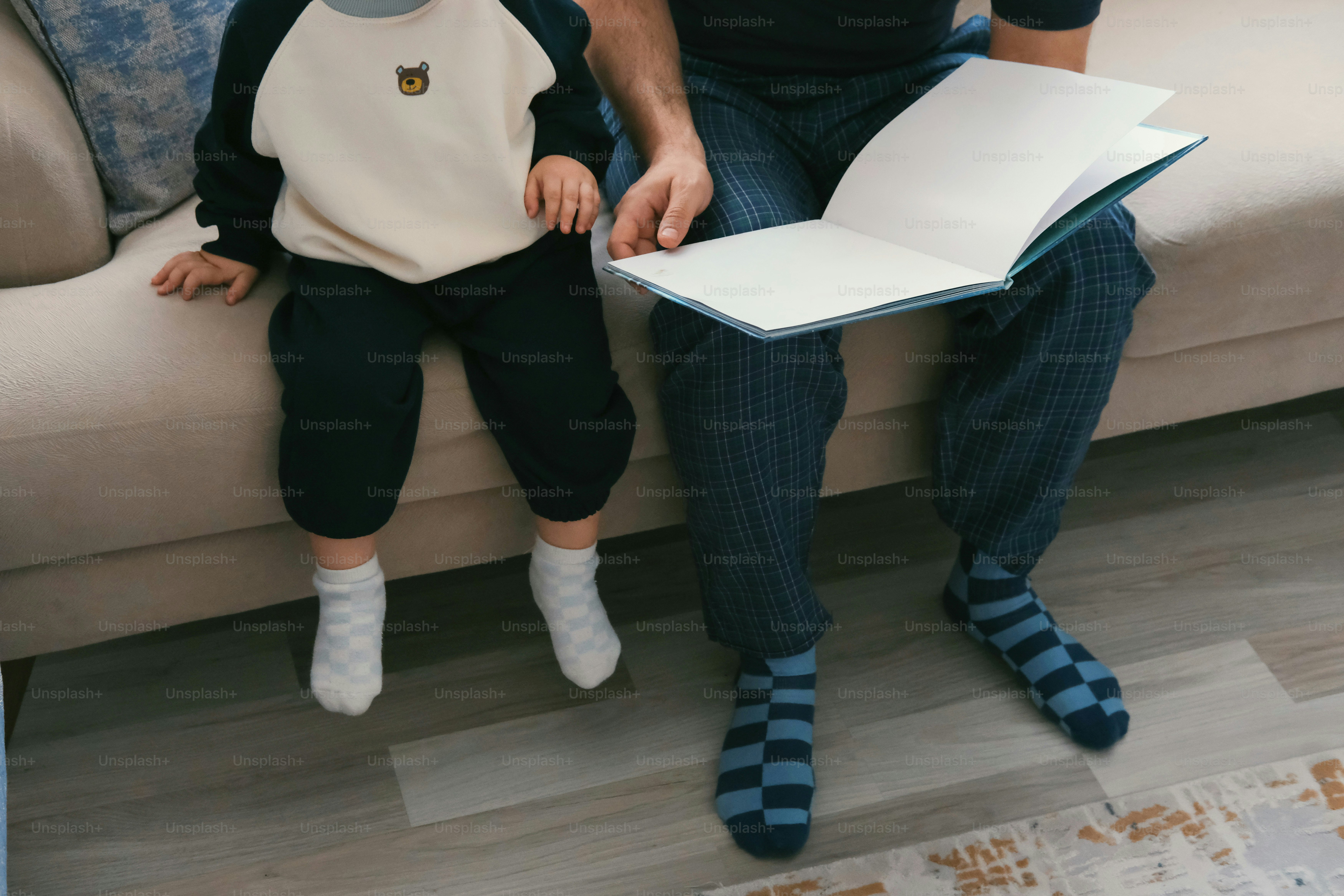 Padre e figlio che leggono un libro insieme sul divano