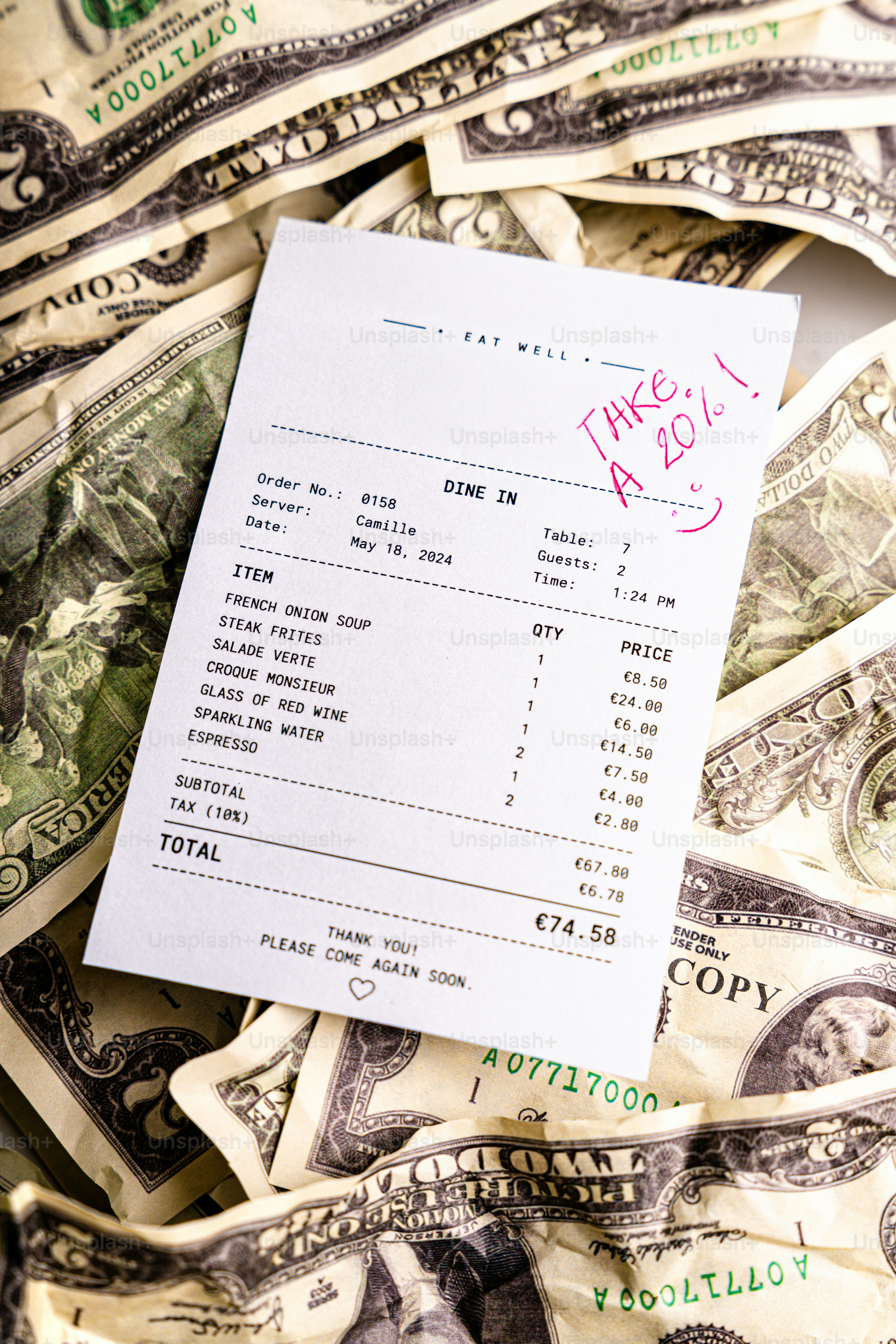 Tagihan restoran dengan catatan tip 20% pada uang dolar.