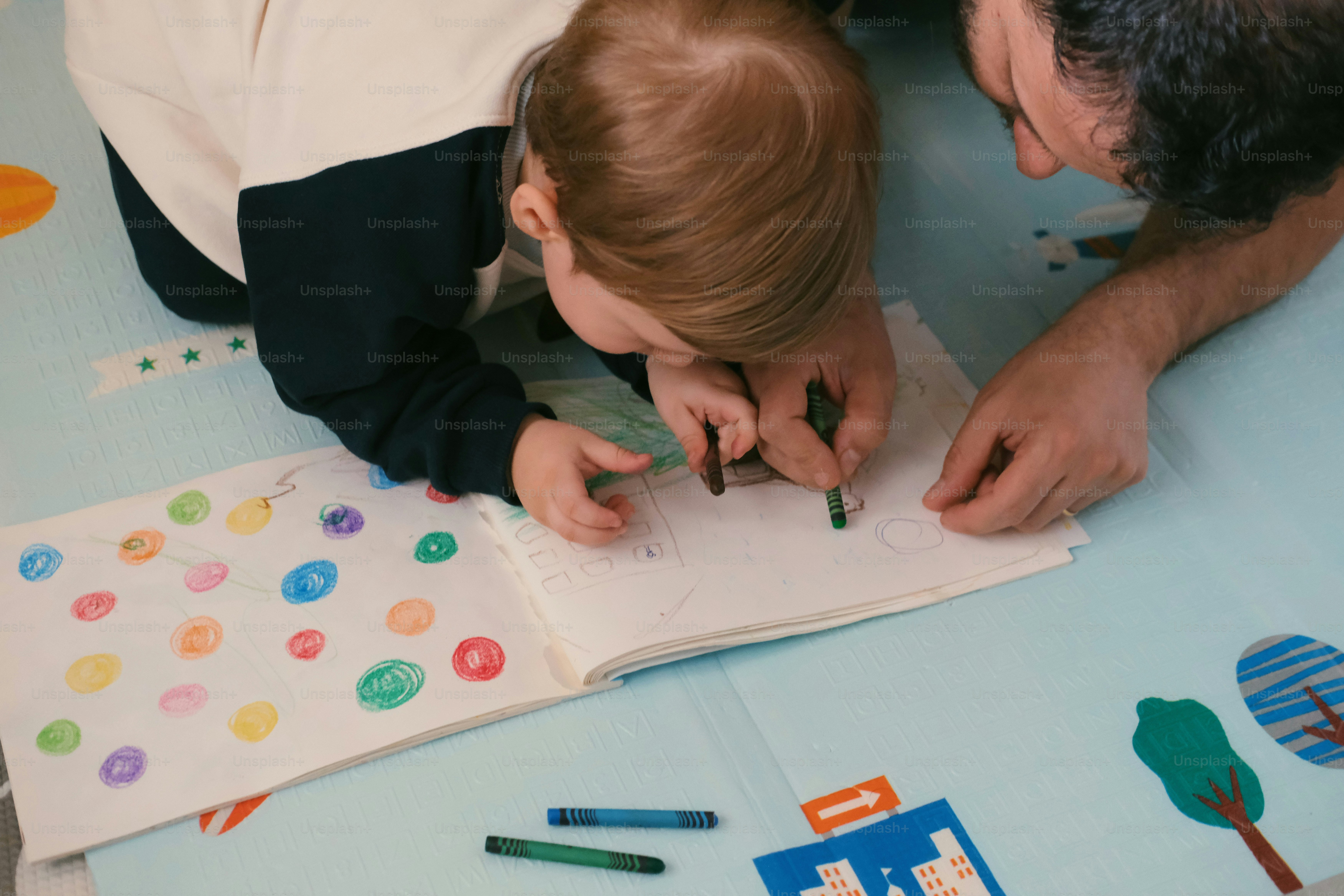 Un bambino e un adulto che colorano insieme con i pastelli