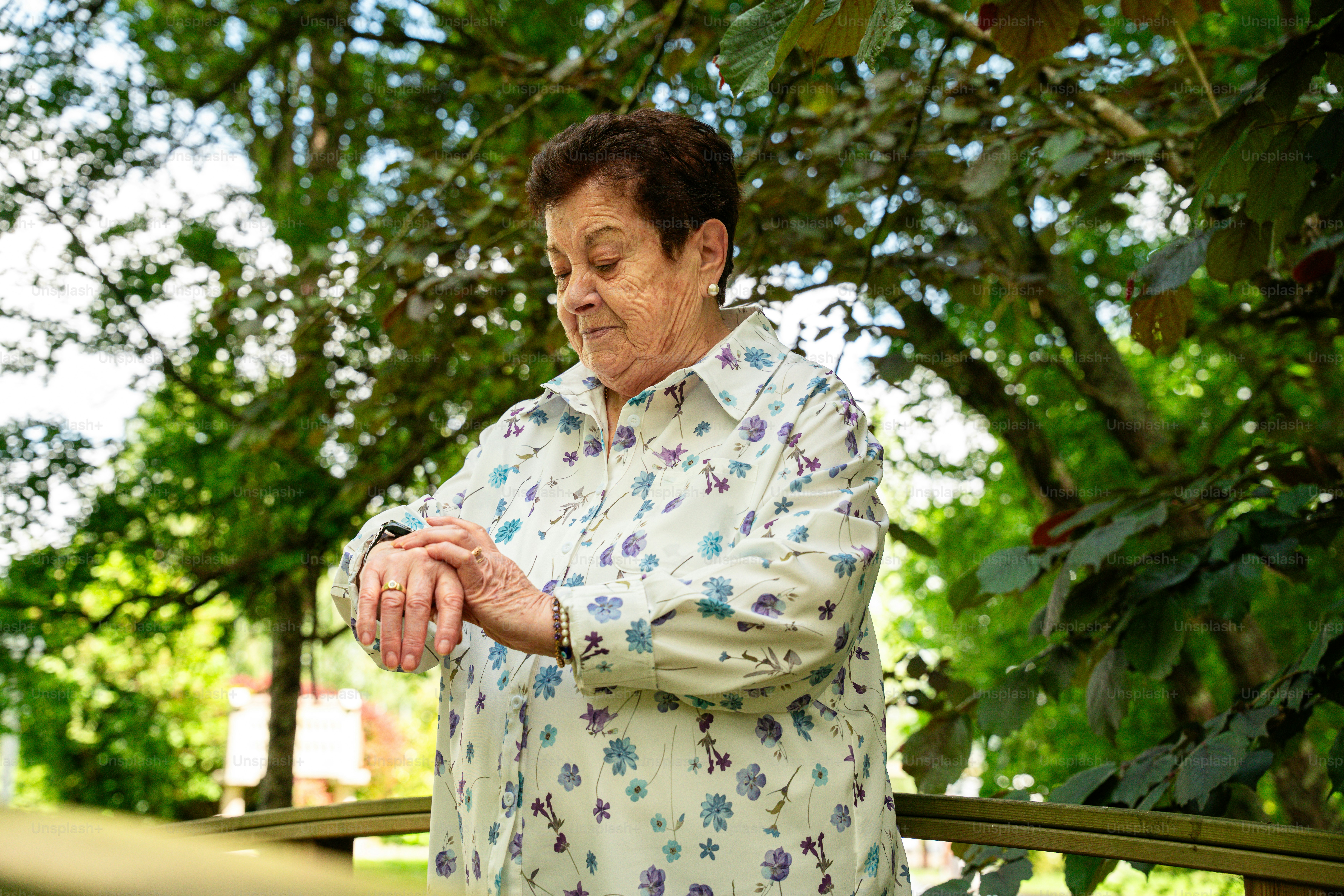 Senior woman using GPS medical alert watch during outdoor walk