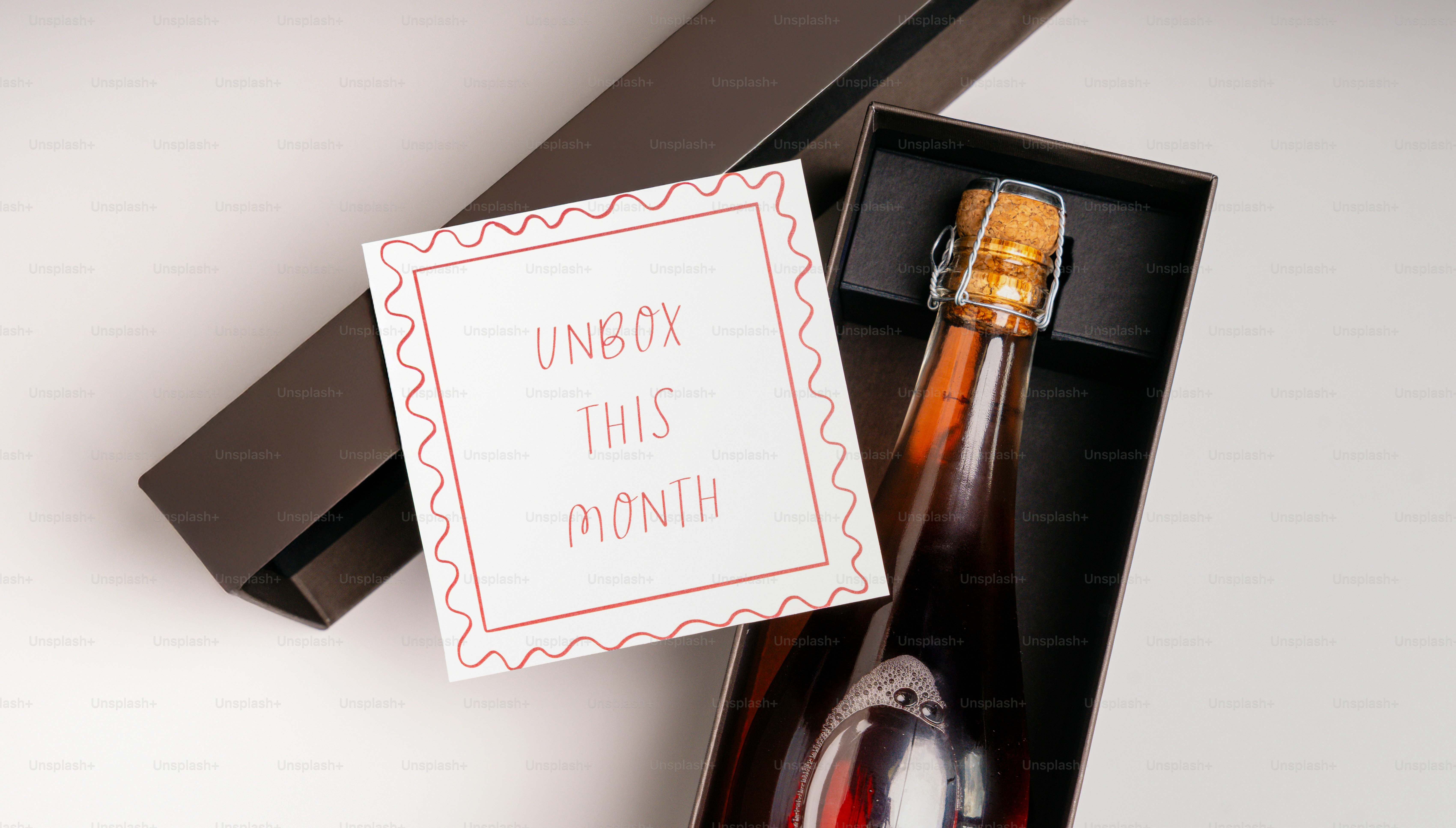 Gift box with a bottle and "unbox this month" card