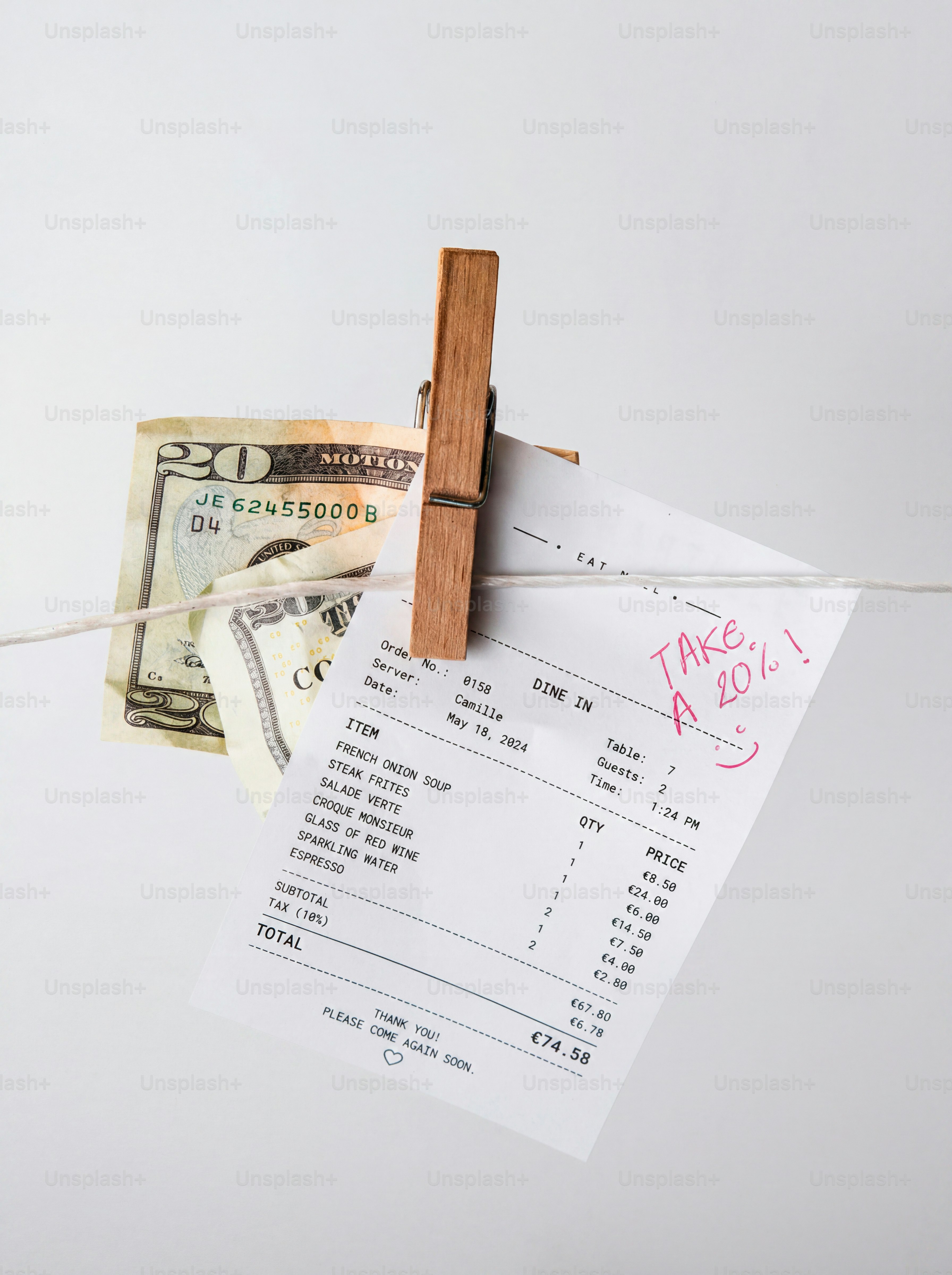 Tanda terima dengan catatan tip 20% dan uang tunai di jemuran.