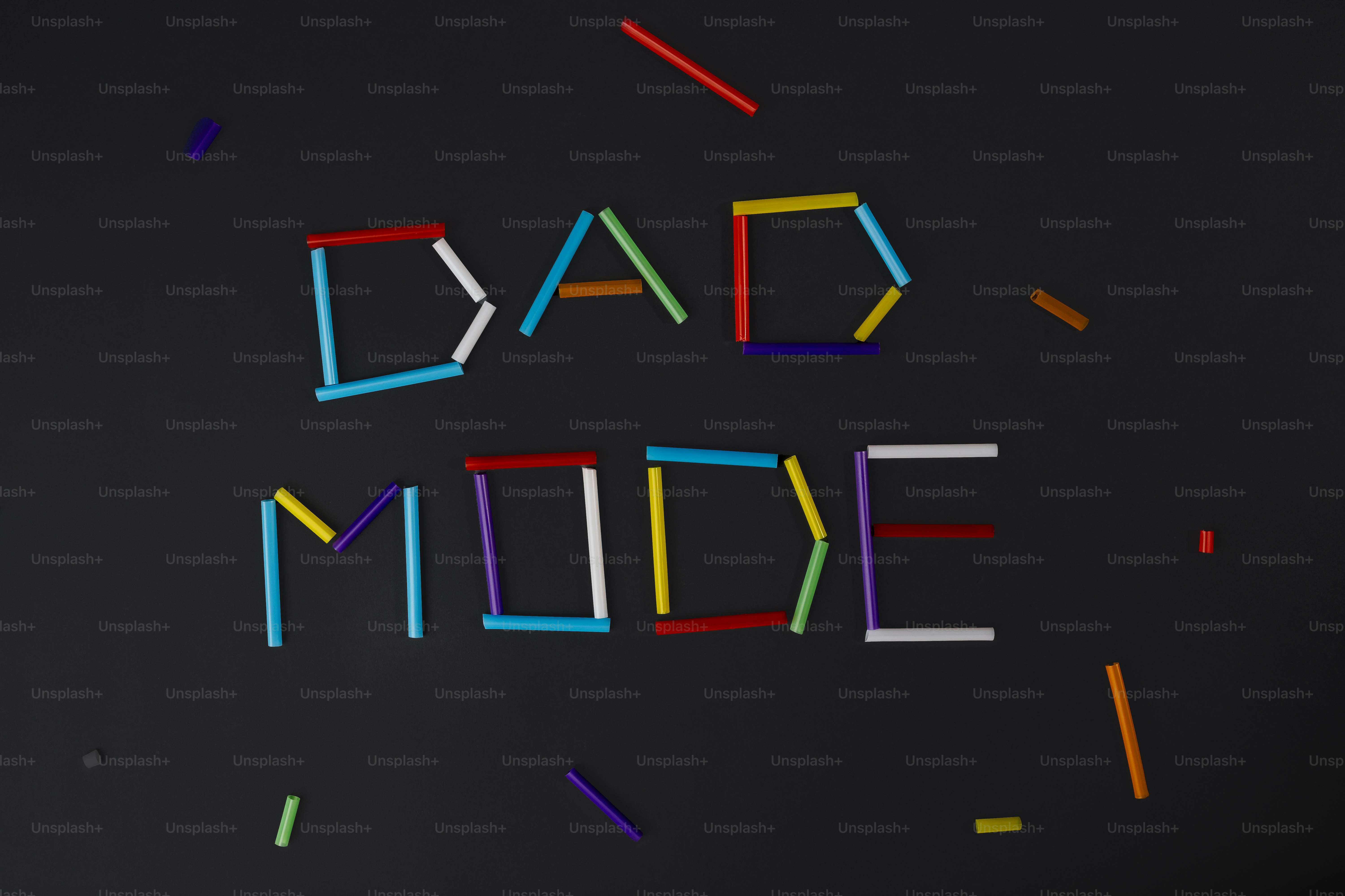 Bunte Stöcke buchstabieren auf dunklem Hintergrund 'Dad-Mode'.