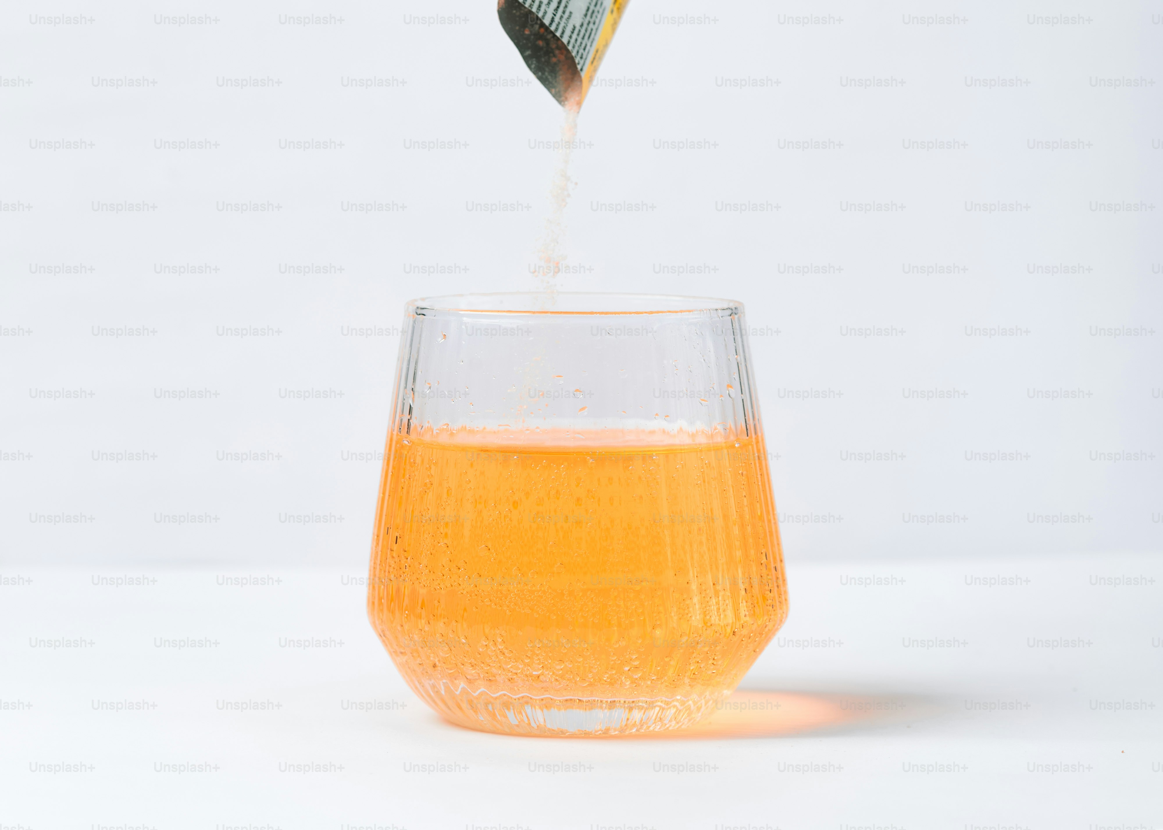 Polvere d'arancia versata in un bicchiere di liquido.