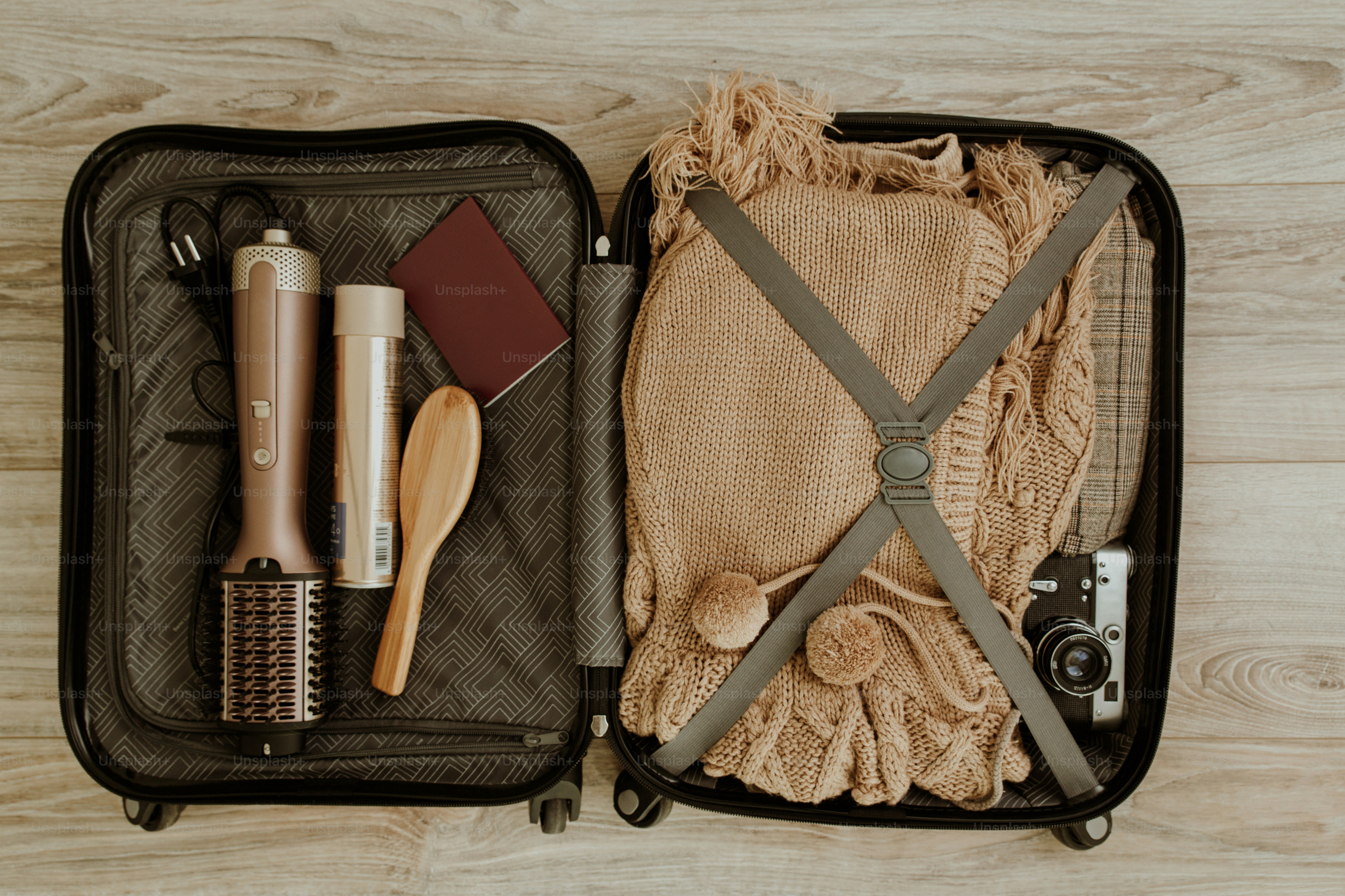 Une valise ouverte remplie de vêtements et d’accessoires de voyage.
