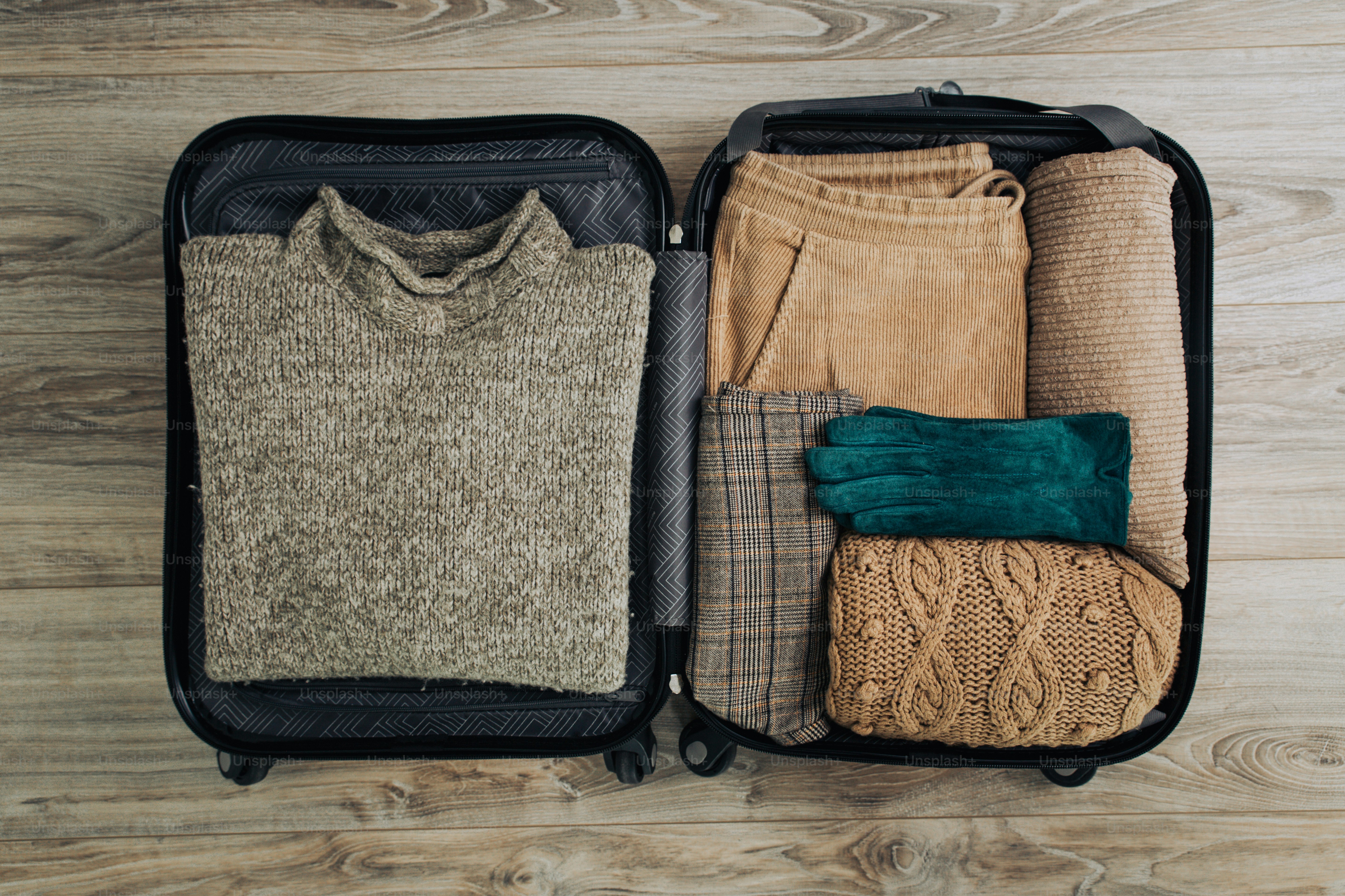 Des vêtements chauds soigneusement rangés dans une valise ouverte.