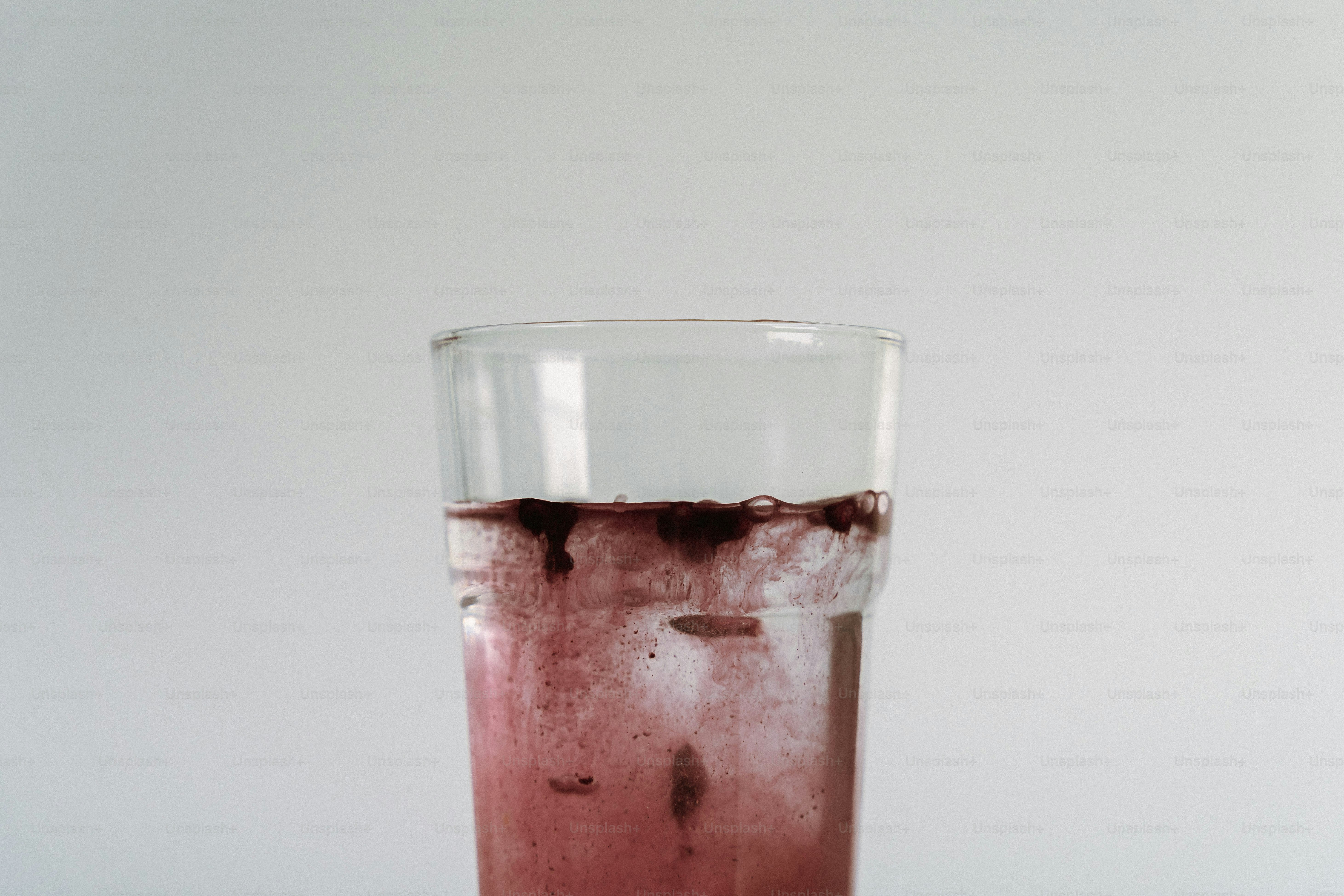 Dunkle Flüssigkeit, die in einem Glas Wasser diffundiert