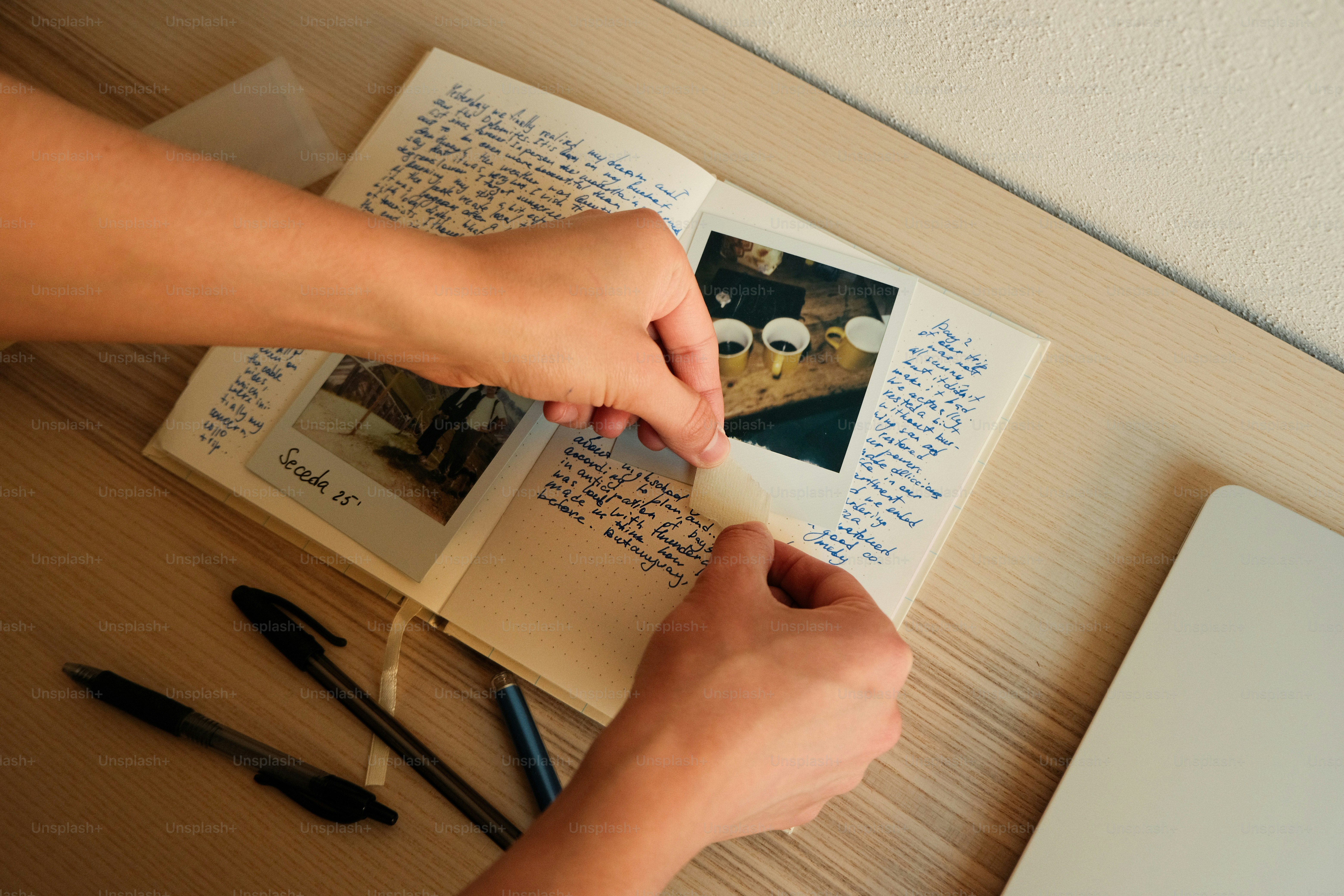 小さな写真をノートに書き込む手。