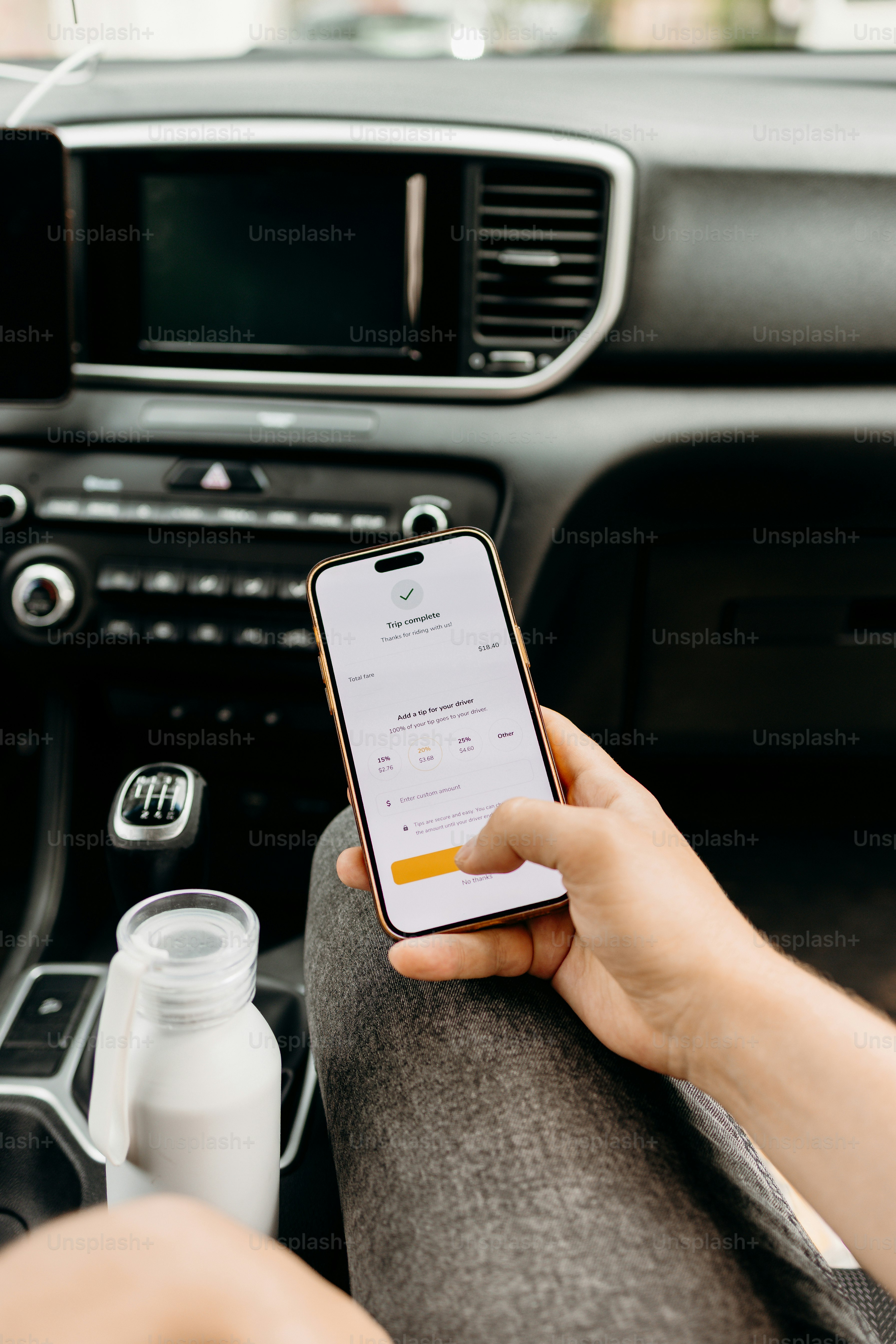 Person holding smartphone with app in car interior