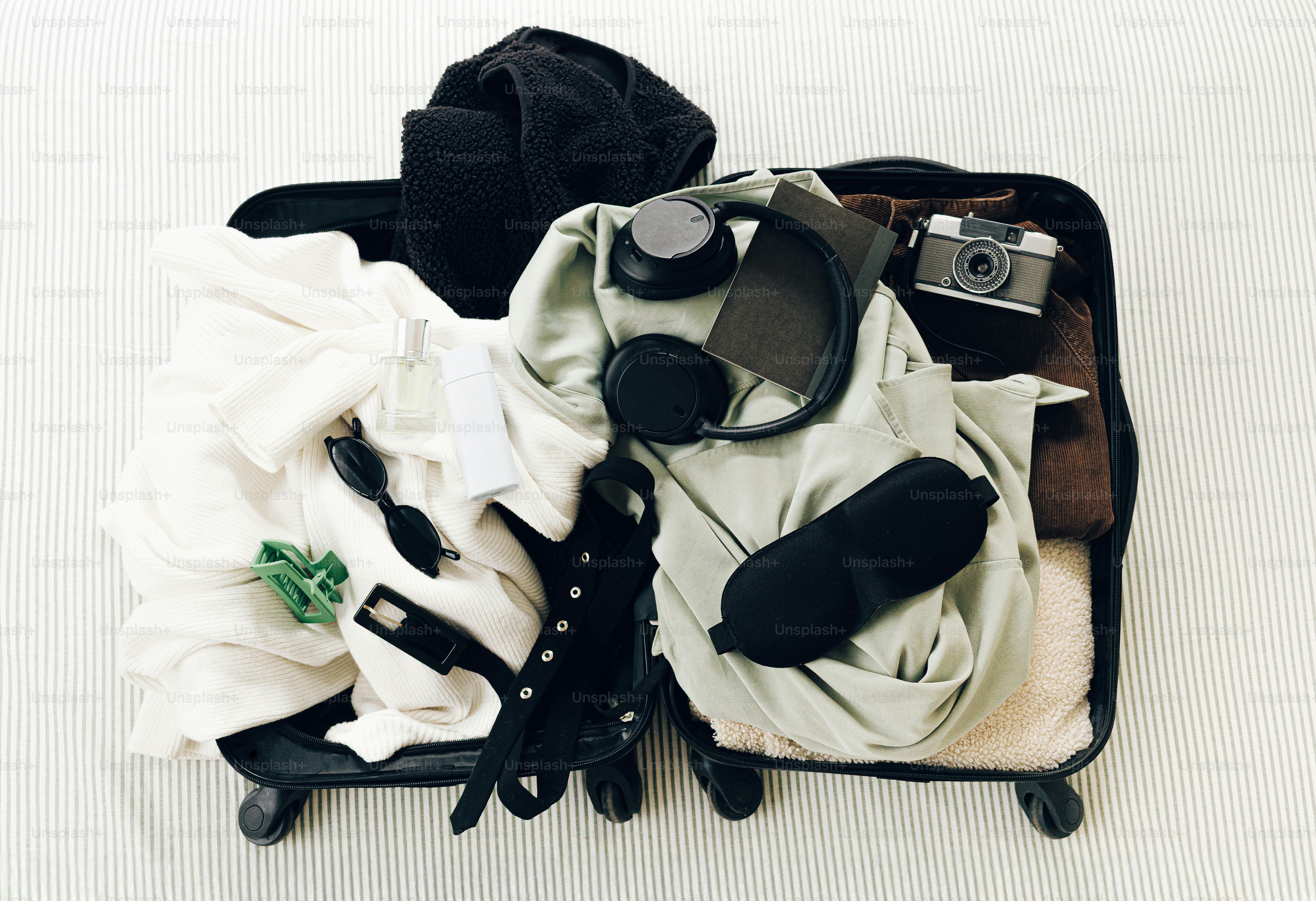 服や旅行必需品が詰まった開いたスーツケース。