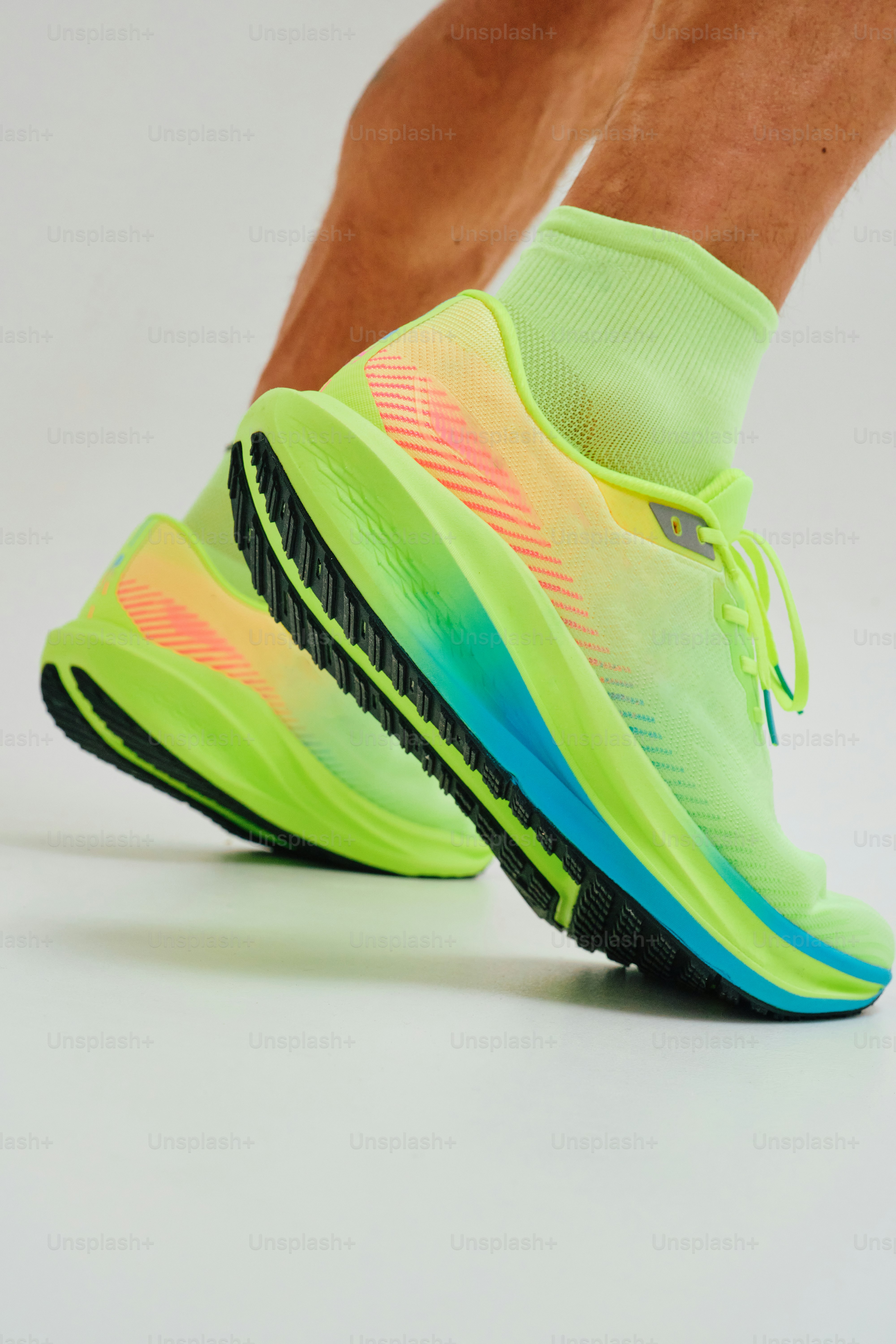 Chaussures de course fluo éclatantes et chaussettes sur fond blanc.