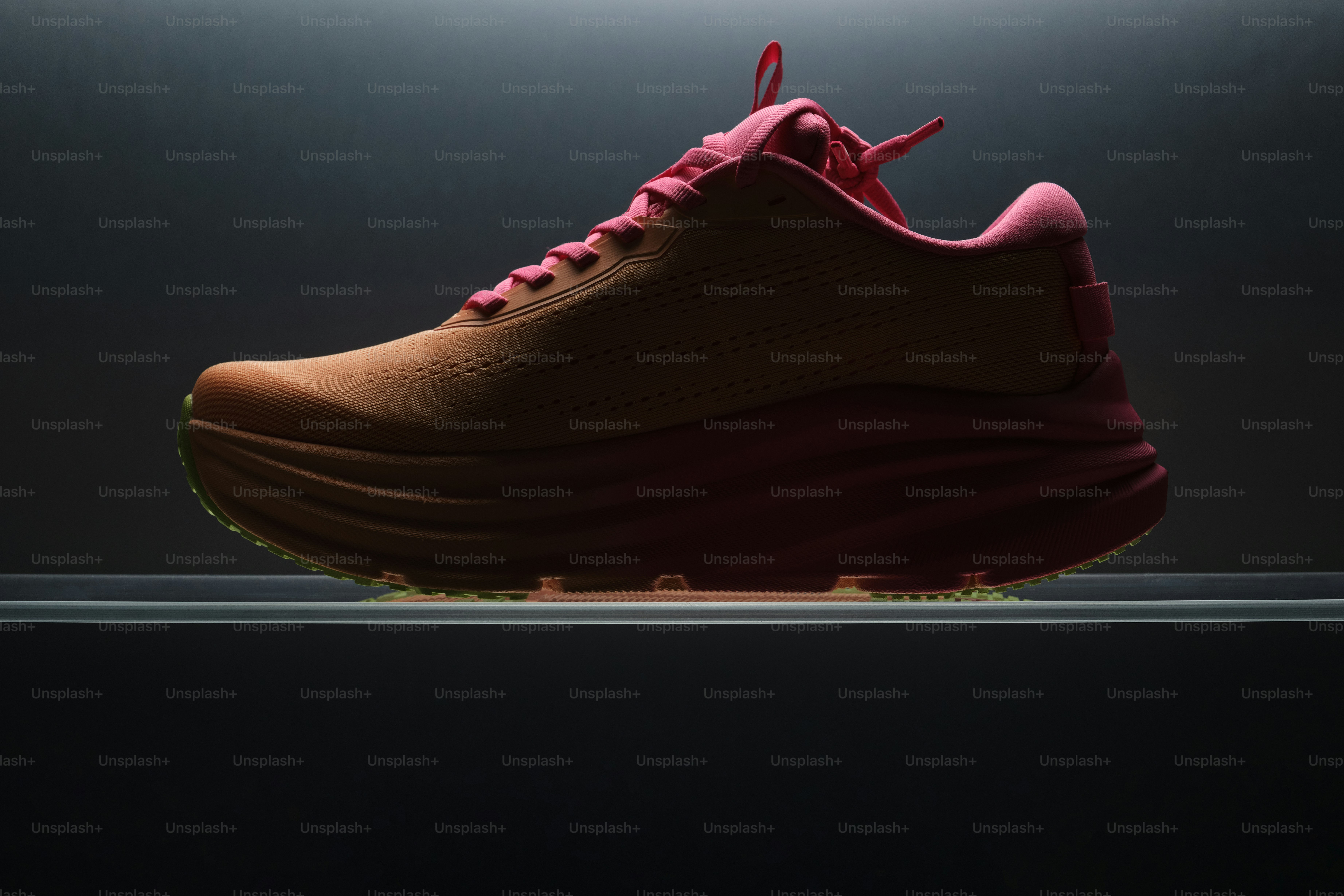 Single red running shoe on a dark background.