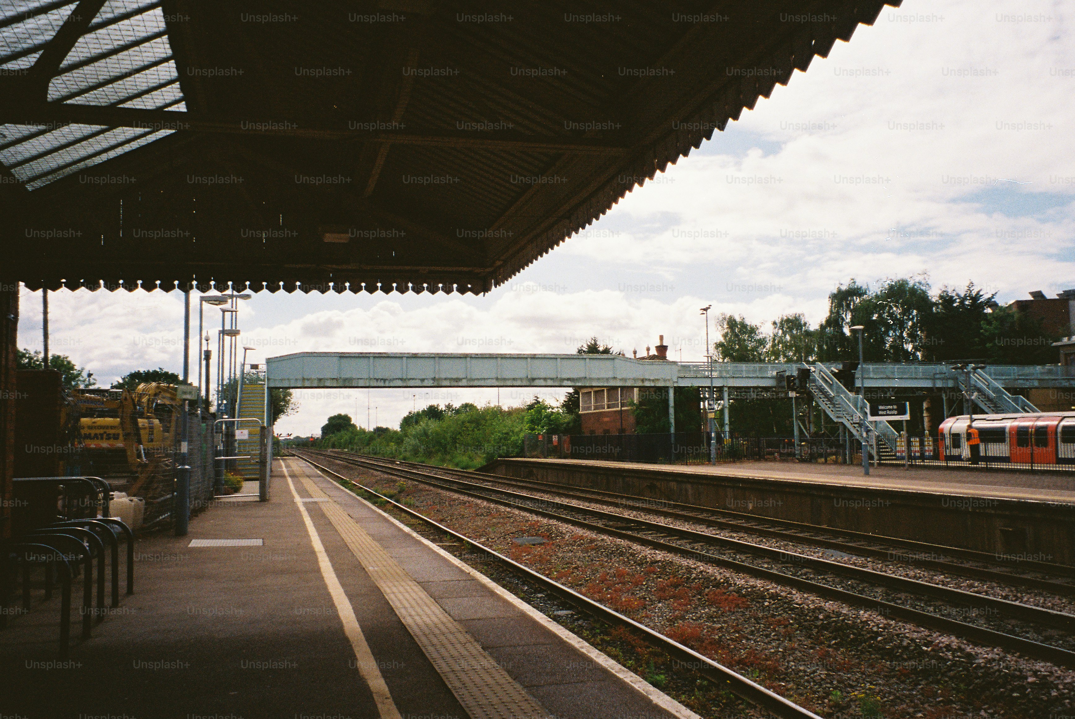 Leerer Bahnsteig mit Gleisen und einer Oberleitung