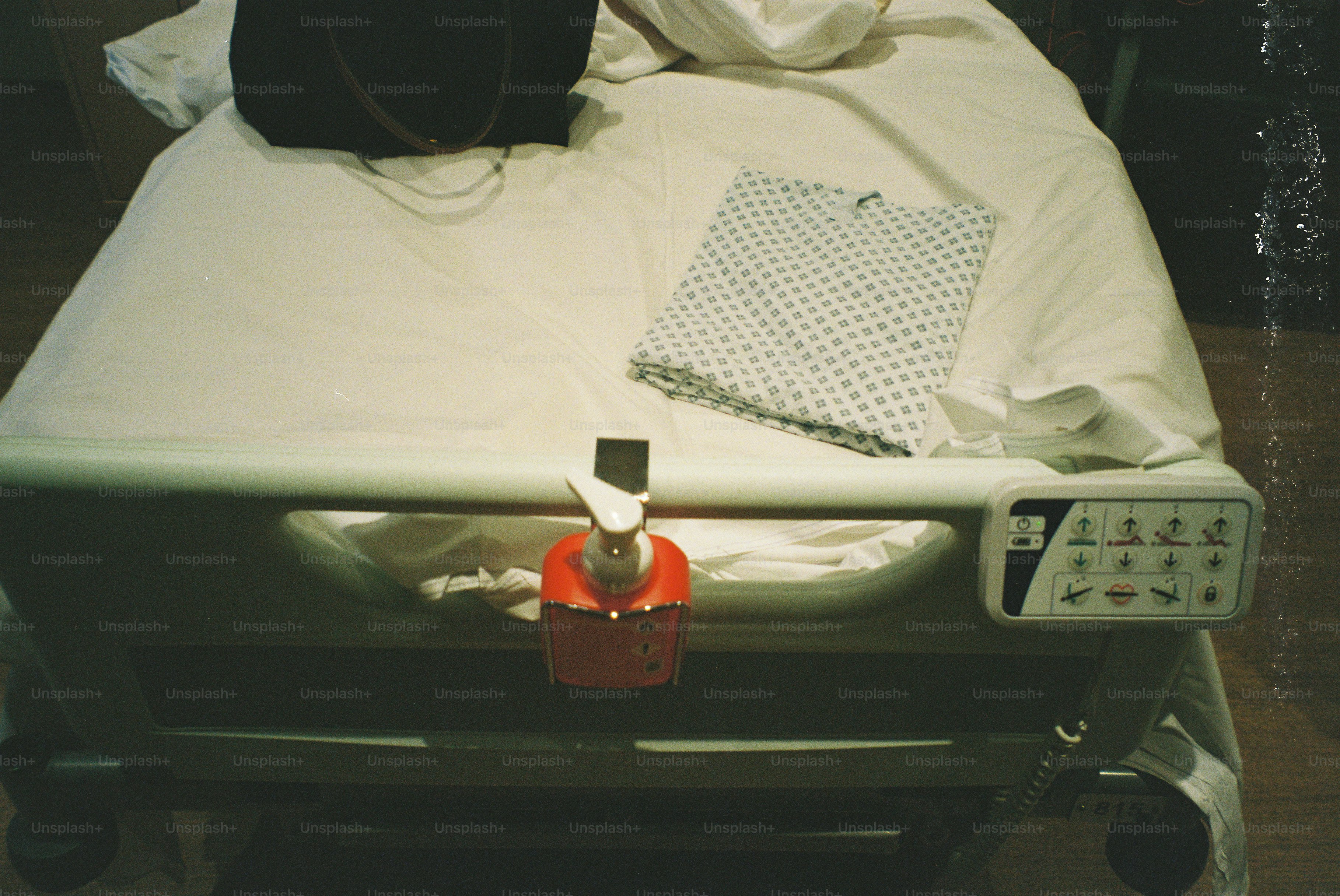 Ein Krankenhausbett mit einer Tasche und einem gemusterten Laken