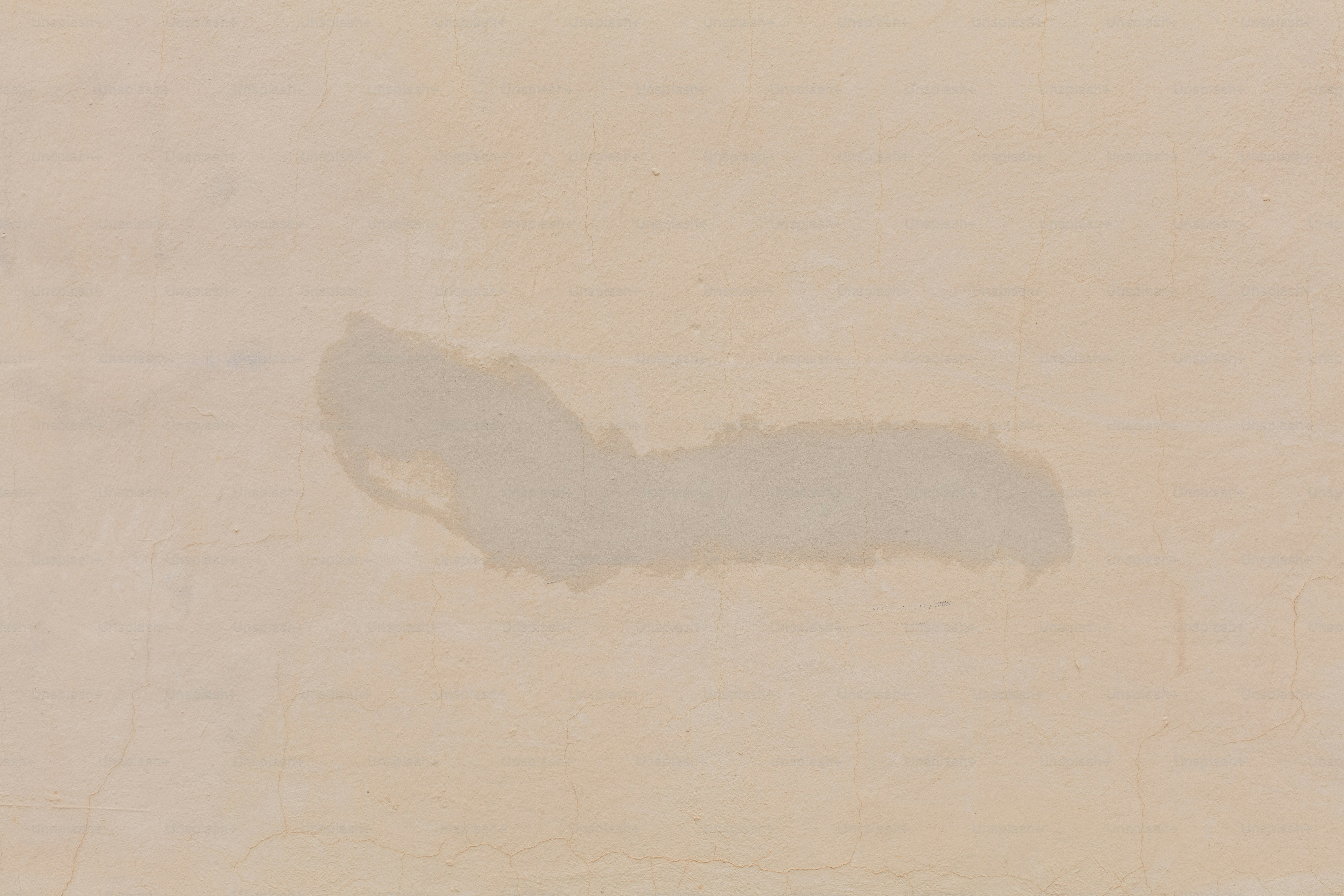 Une tache humide sur une surface brun clair.