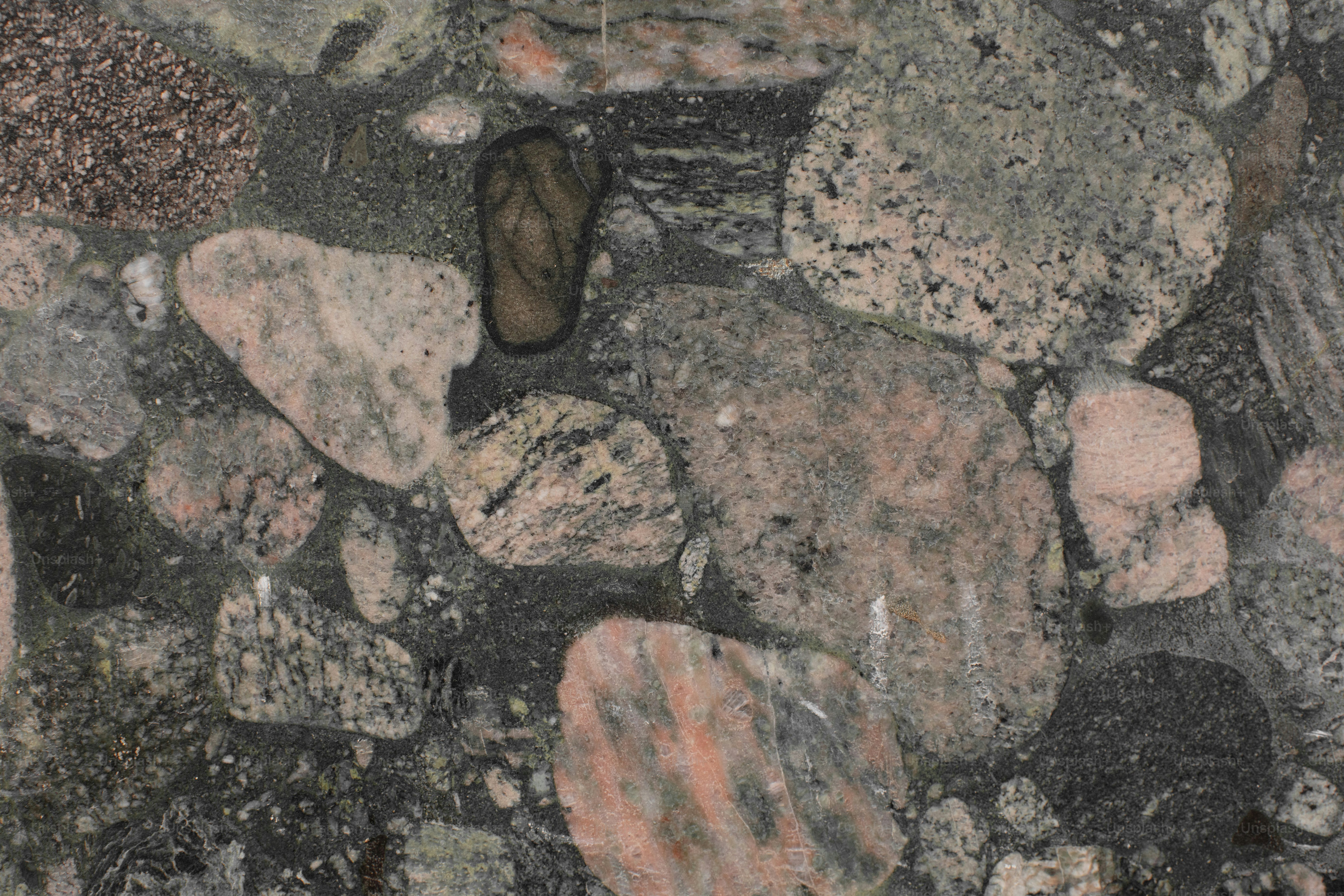 Piedras incrustadas y una chancla sobre una superficie oscura.