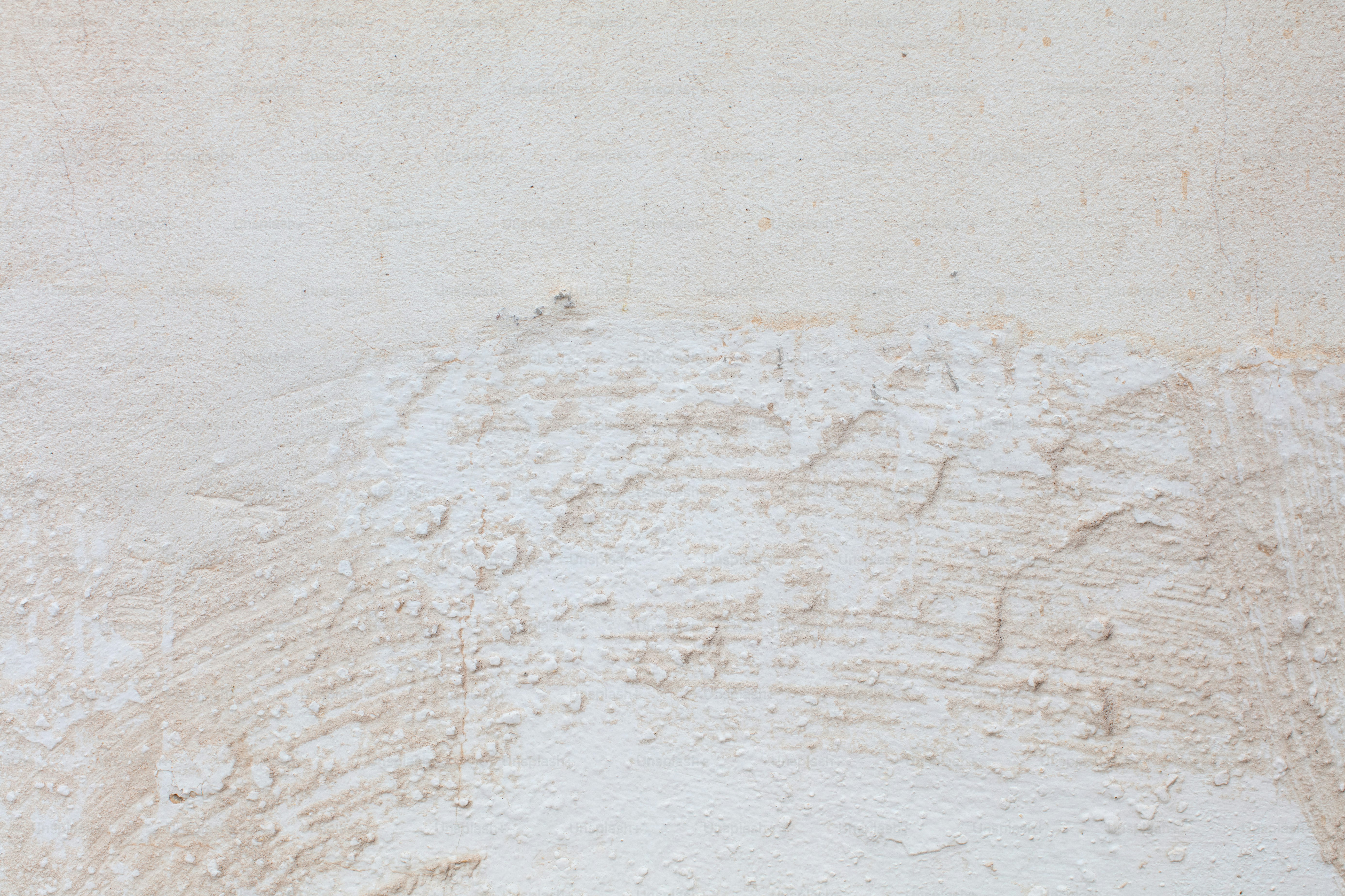 White concrete wall displaying rough, textured surface with visible markings