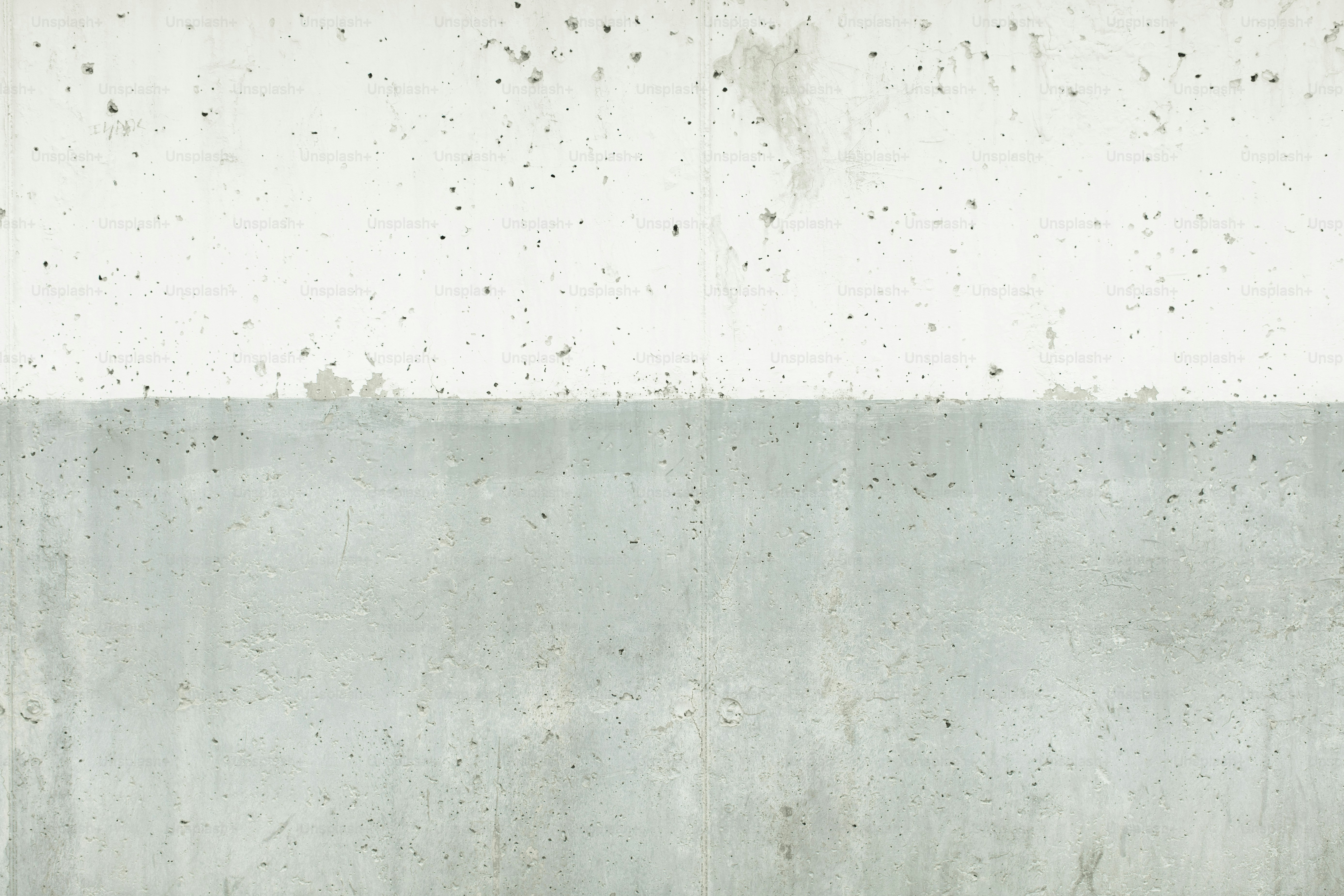 Rough concrete wall displaying a distinct dual tone texture and minimalist design