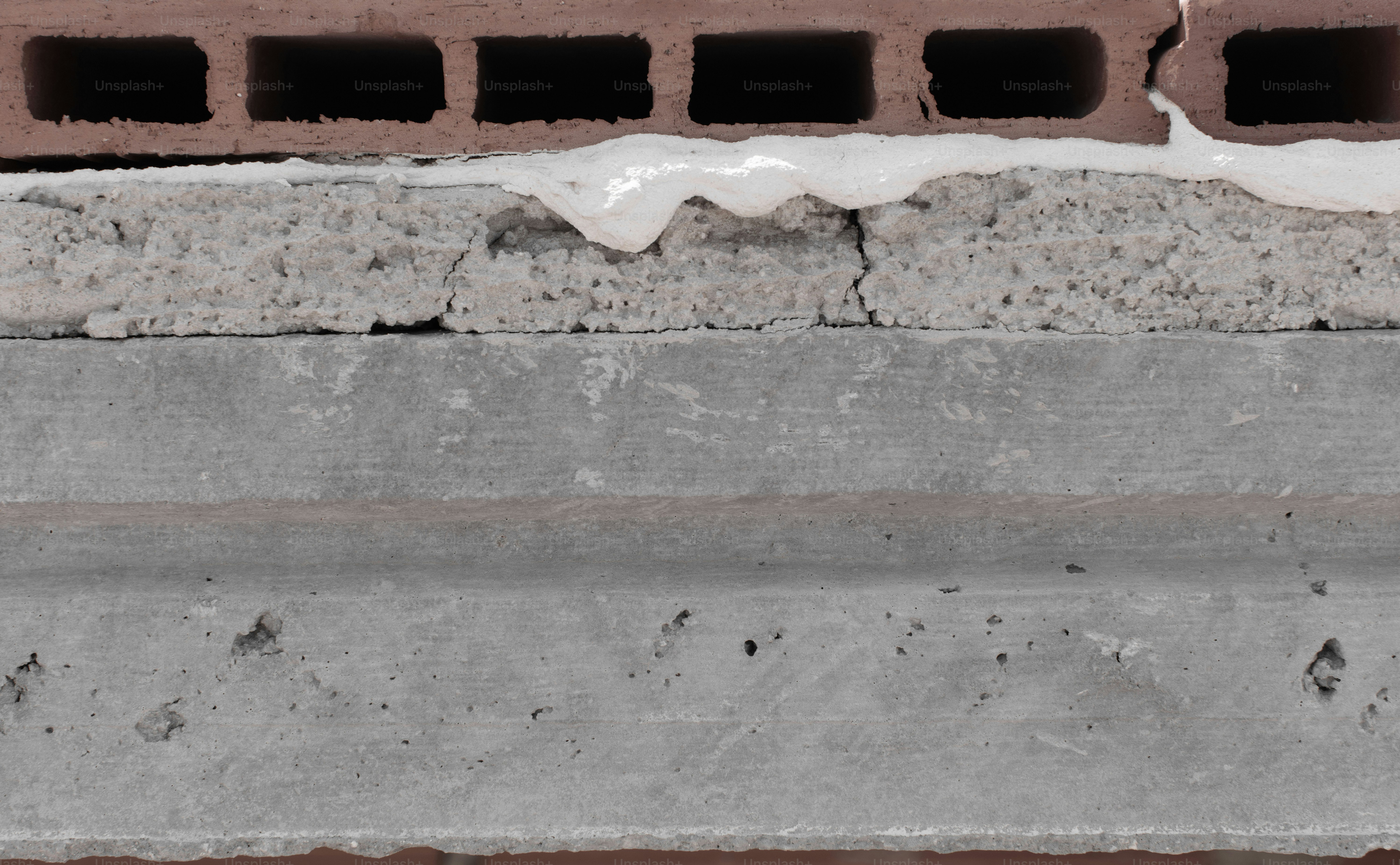 Construction wall detailing exposed concrete, grout, and hollow clay brick materials