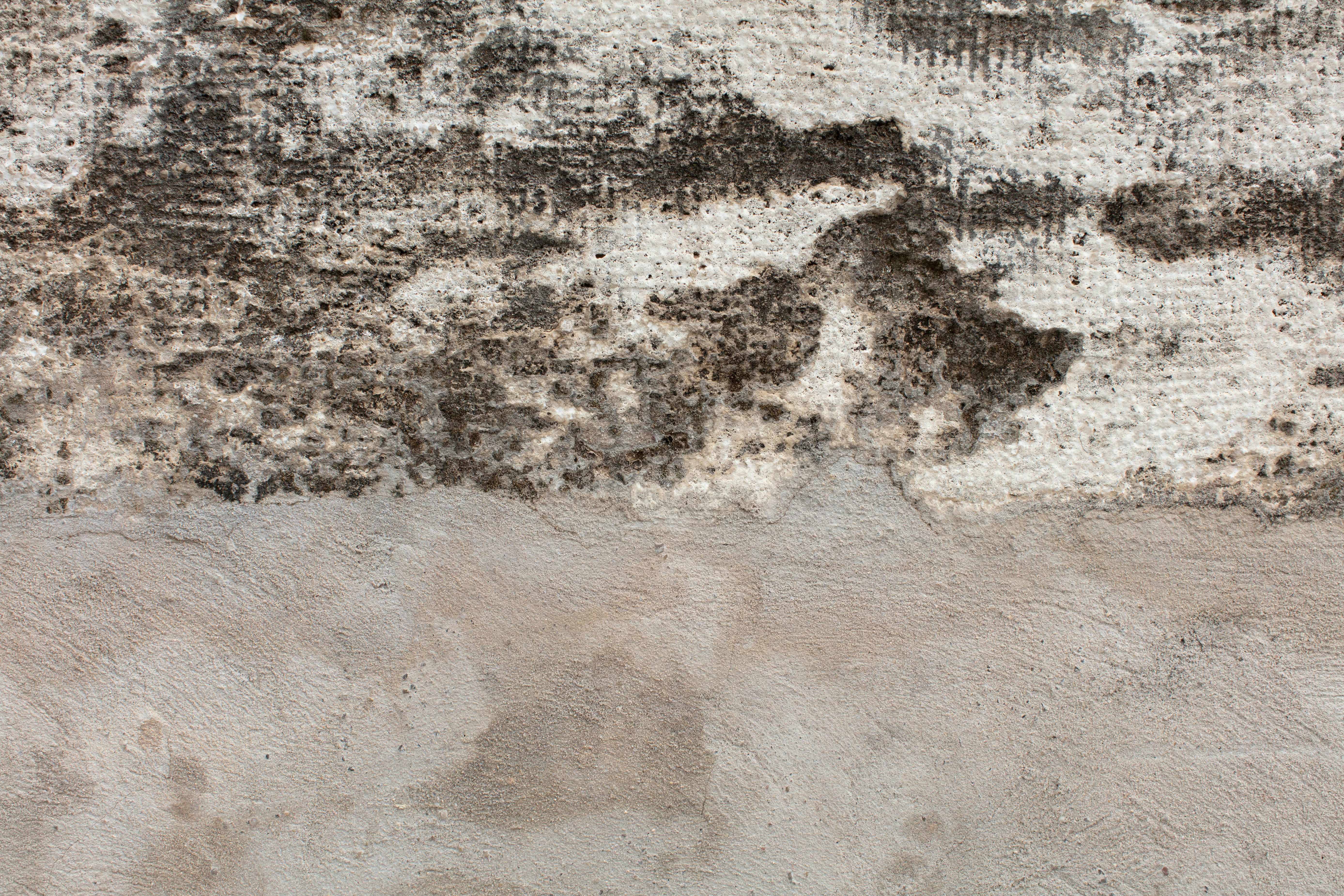 Mur à texture crasse, tachées foncées et plâtre plus clair.