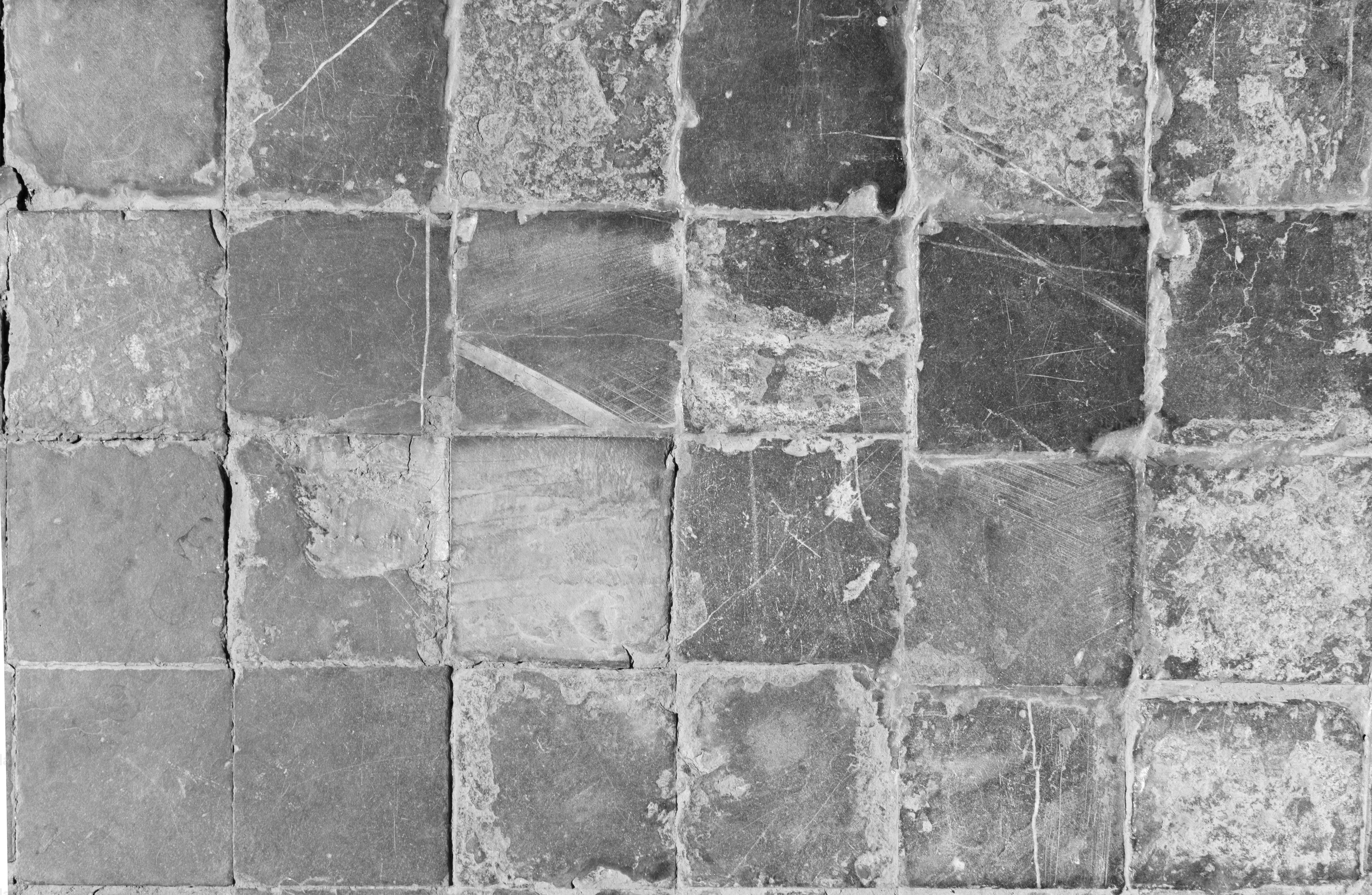 A grid of worn, textured, square tiles in grayscale. photo – Wallpaper ...