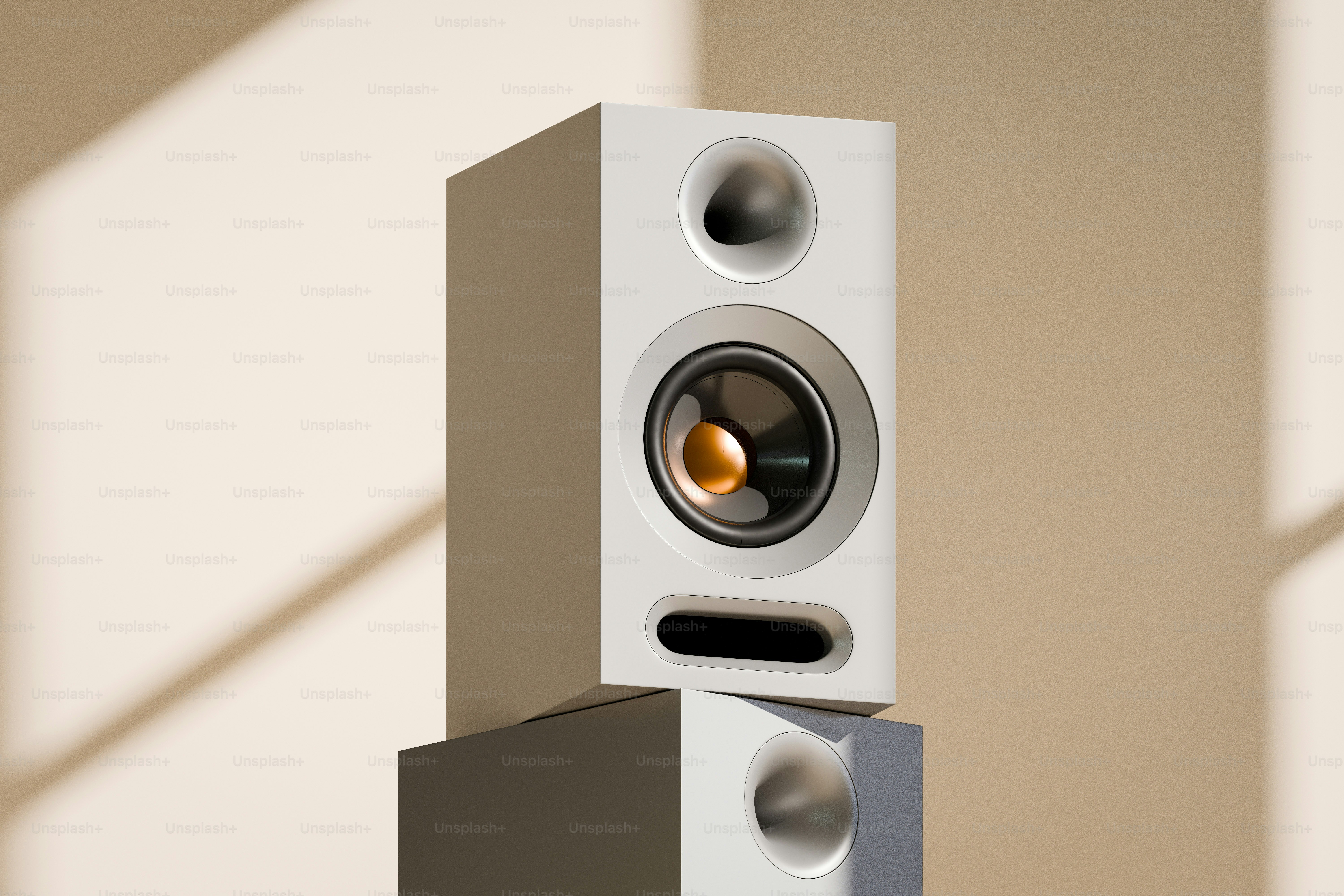 Speaker putih modern dengan kerucut emas ditumpuk pada speaker lain.